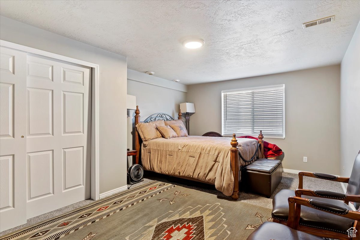 Bedroom with carpet and a textured ceiling