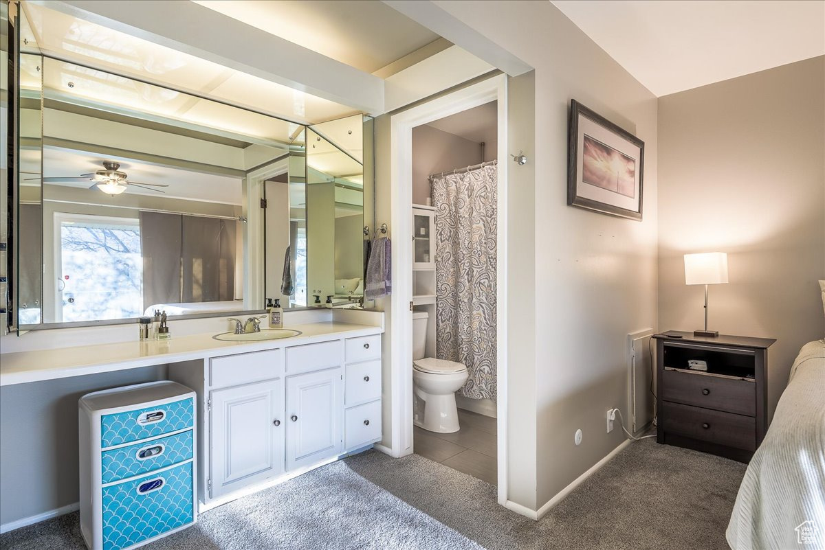 Bathroom featuring vanity, toilet, tile floors, and ceiling fan