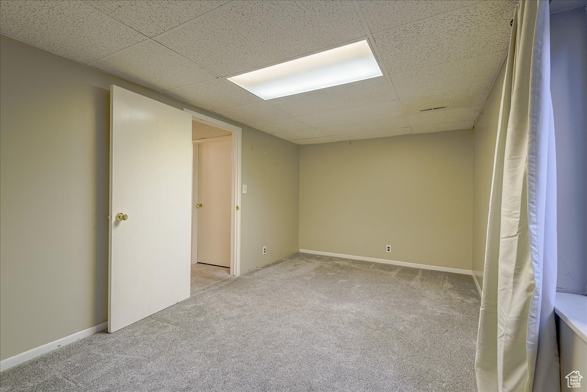 Carpeted empty room with a drop ceiling