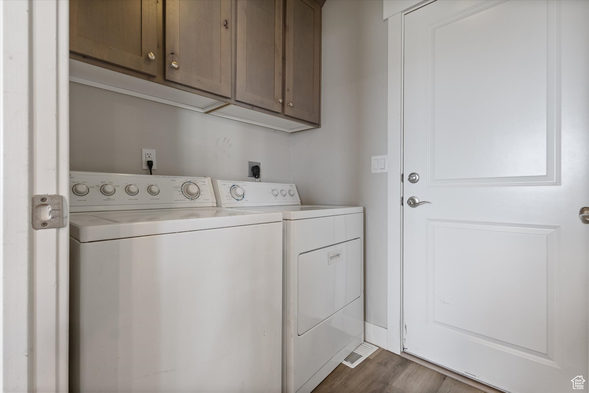 Laundry room with cabinets, electric dryer hookup, separate washer and dryer, and dark hardwood / wood-style floors