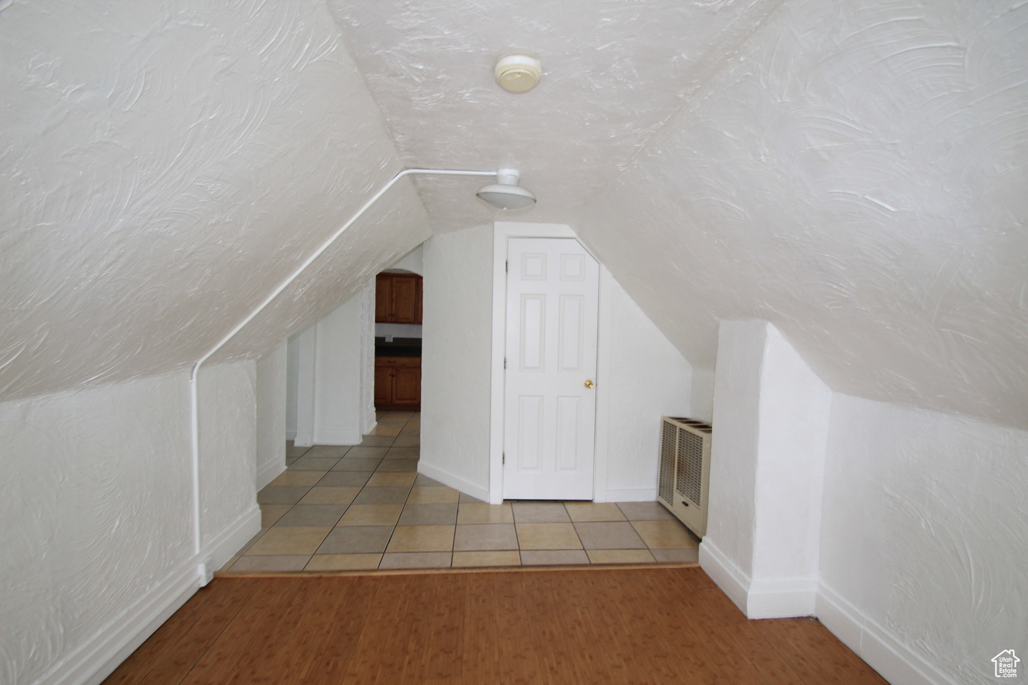 Bonus room featuring light hardwood / wood-style flooring and lofted ceiling