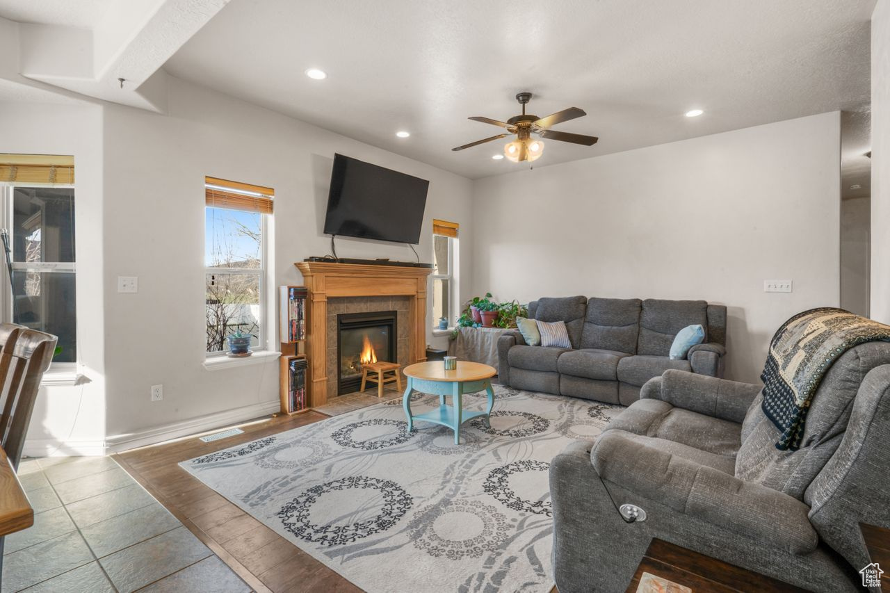Living room featuring light hardwood / wood-style flooring, ceiling fan, and a tile fireplace