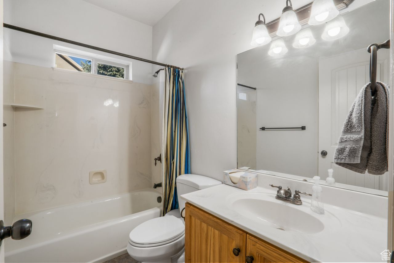 Full bathroom with shower / tub combo, toilet, and vanity