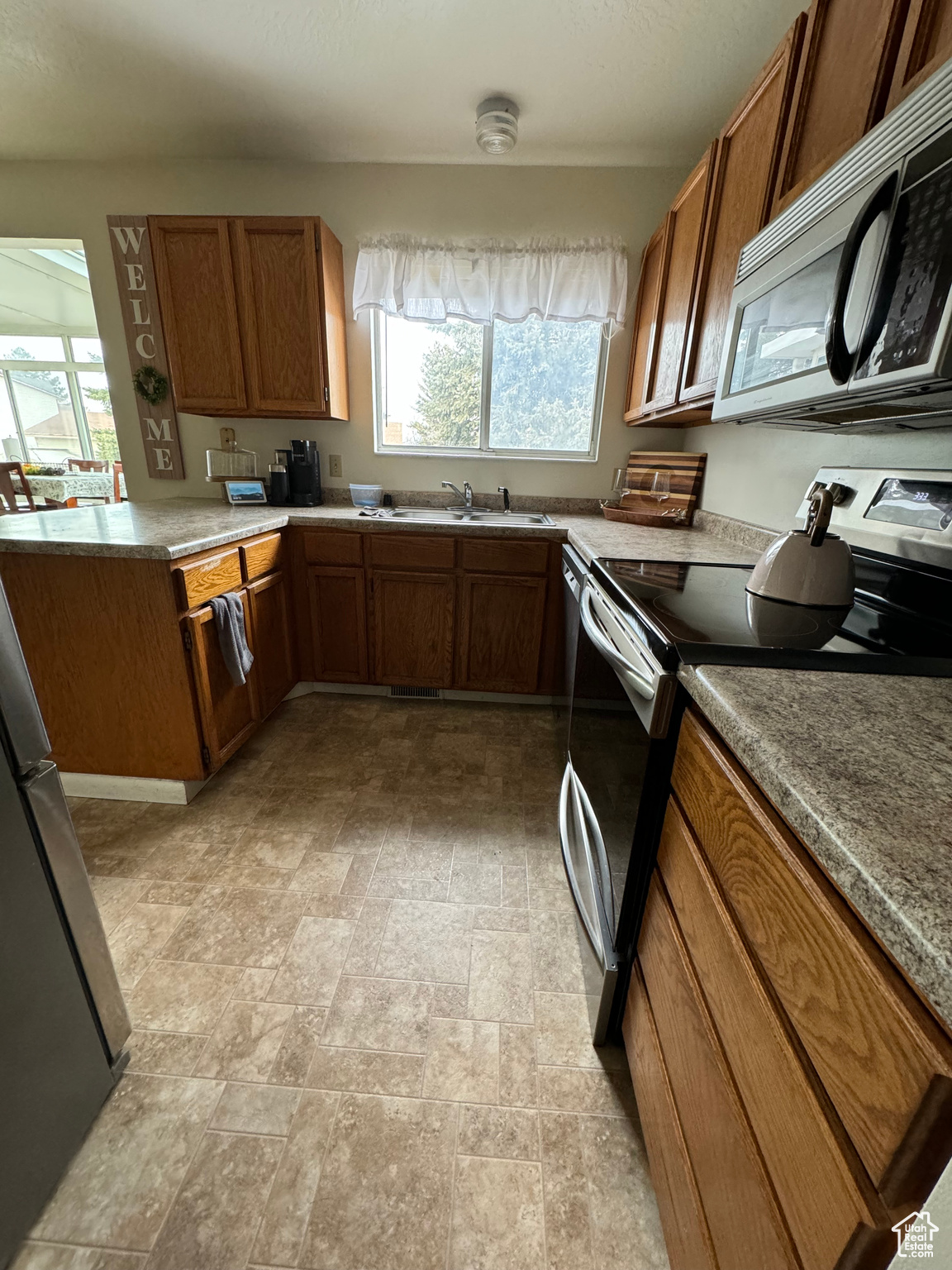 Kitchen with sink, appliances with stainless steel finishes, and light tile floors