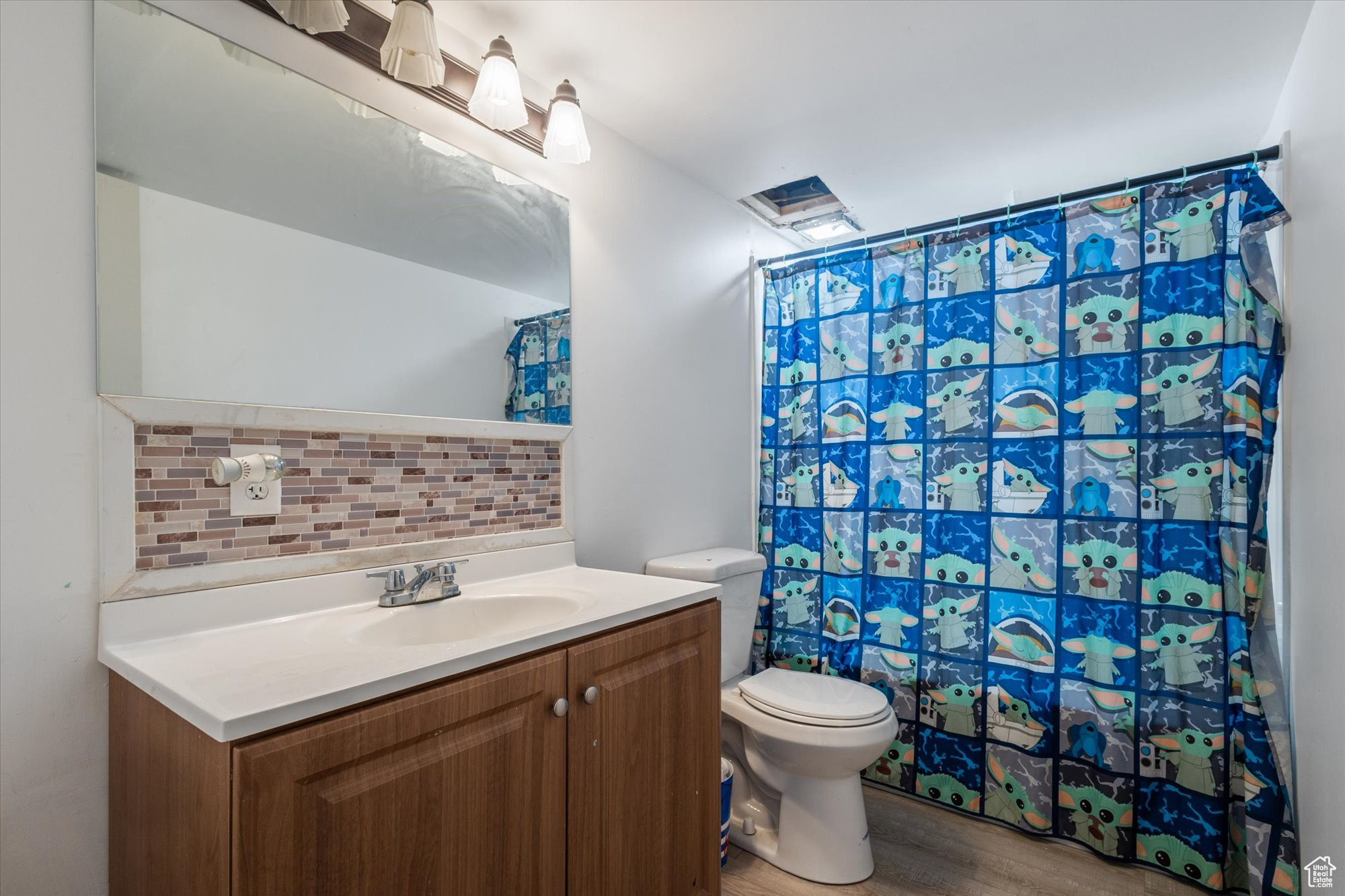 Bathroom featuring backsplash, vanity, hardwood / wood-style flooring, and toilet