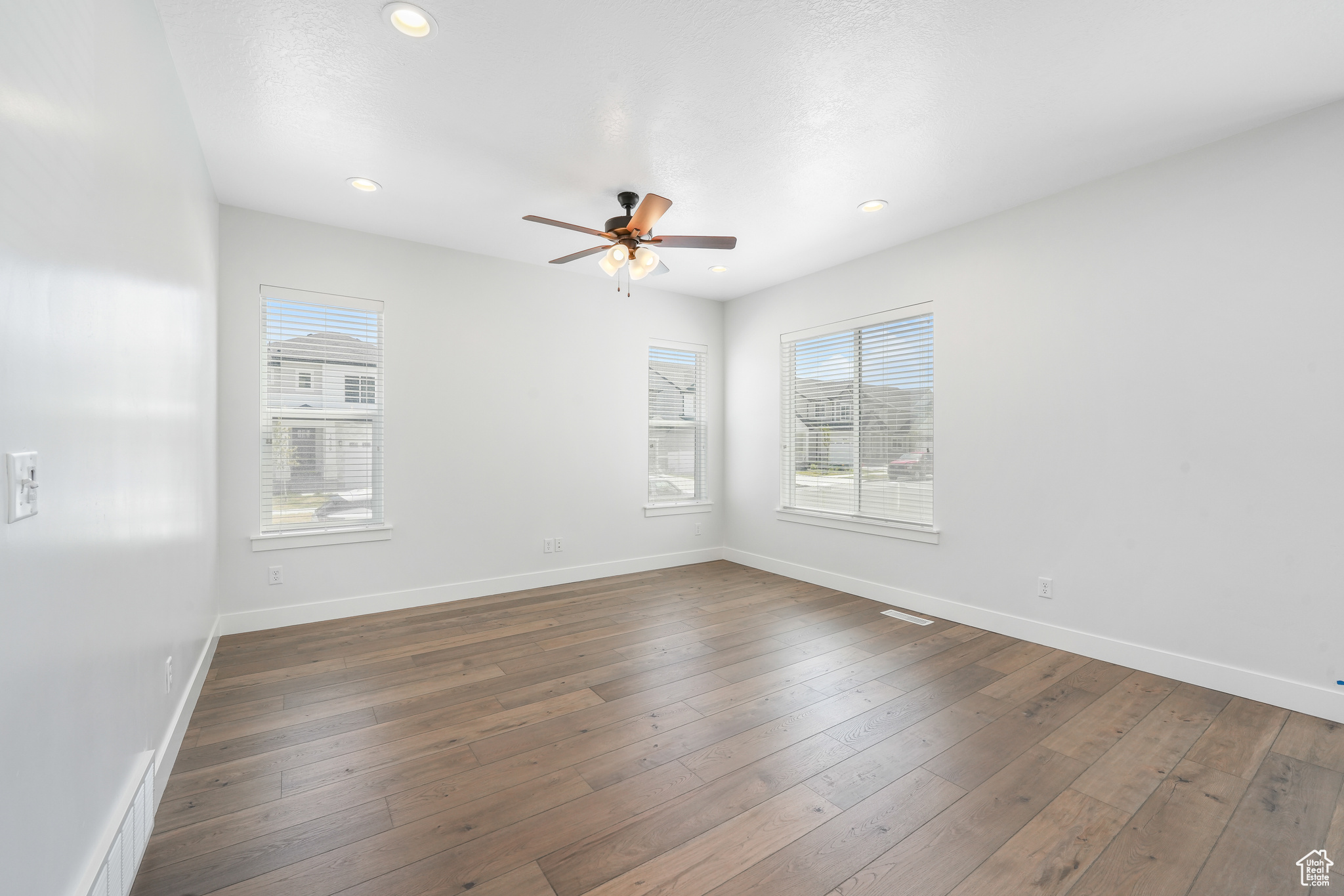 Spare room with dark hardwood / wood-style flooring and ceiling fan