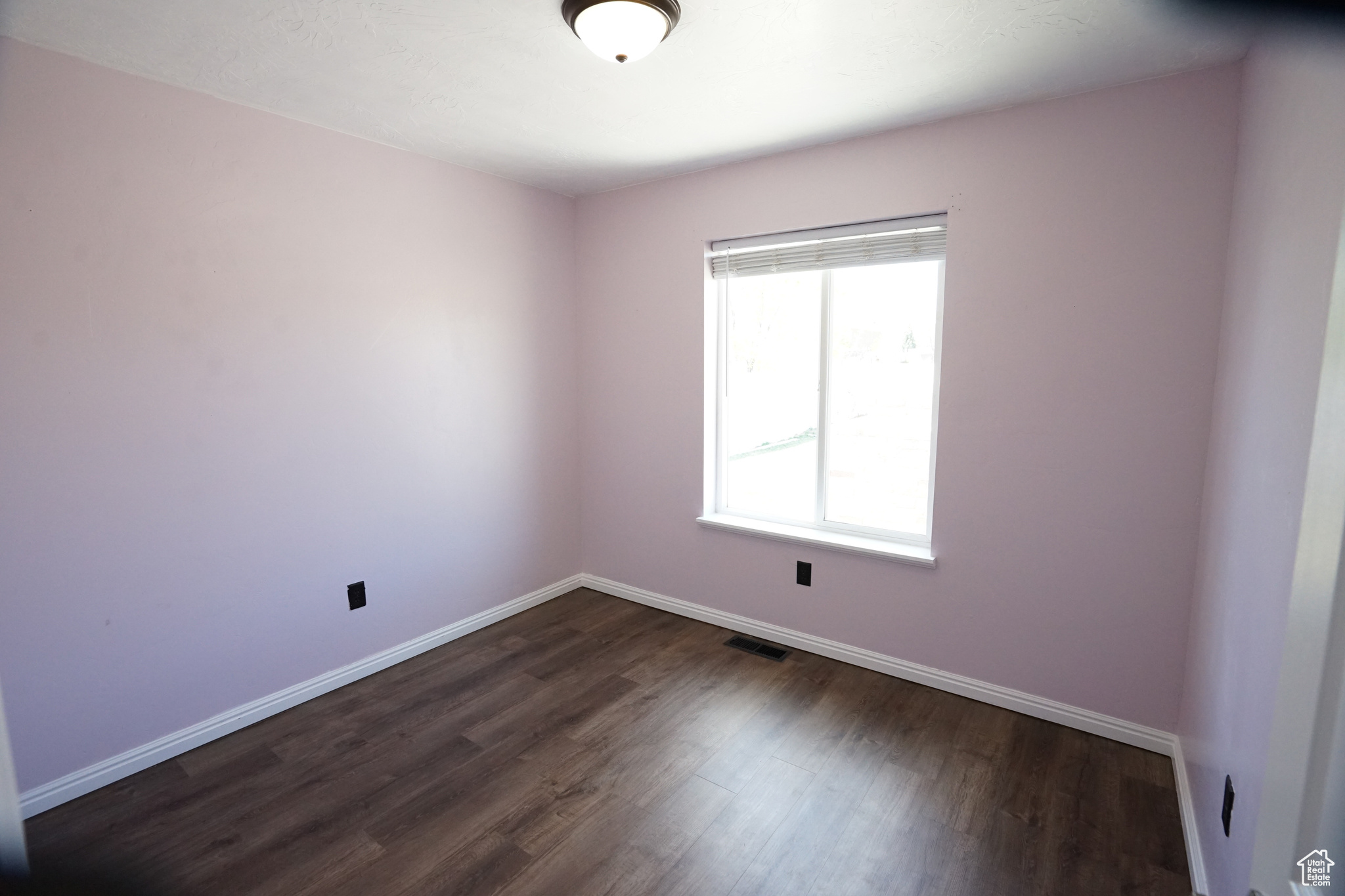 Spare room with plenty of natural light and dark hardwood / wood-style floors
