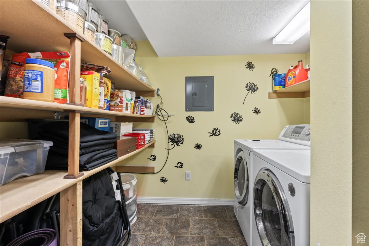 Laundry area with dark tile flooring, separate washer and dryer, and a textured ceiling