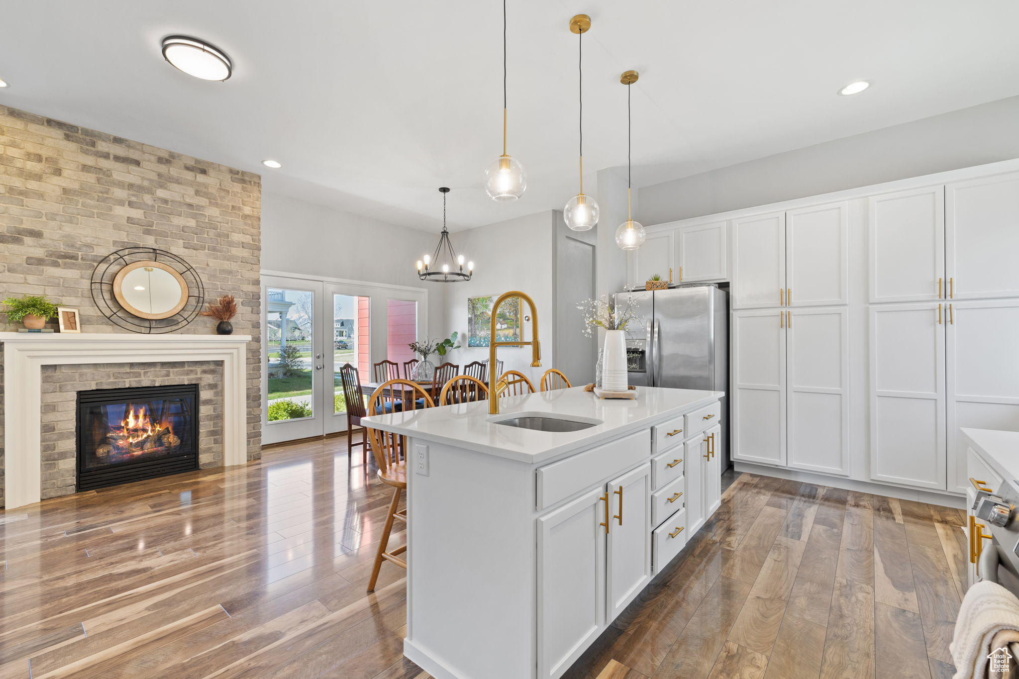Kitchen featuring white cabinets, hardwood / wood-style floors, stainless steel refrigerator with ice dispenser, and pendant lighting