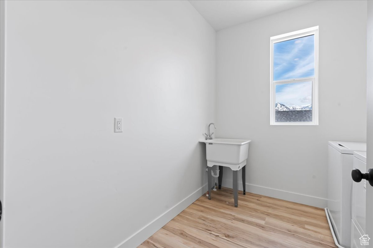 Washroom with plenty of natural light, light hardwood / wood-style flooring, and washer and dryer