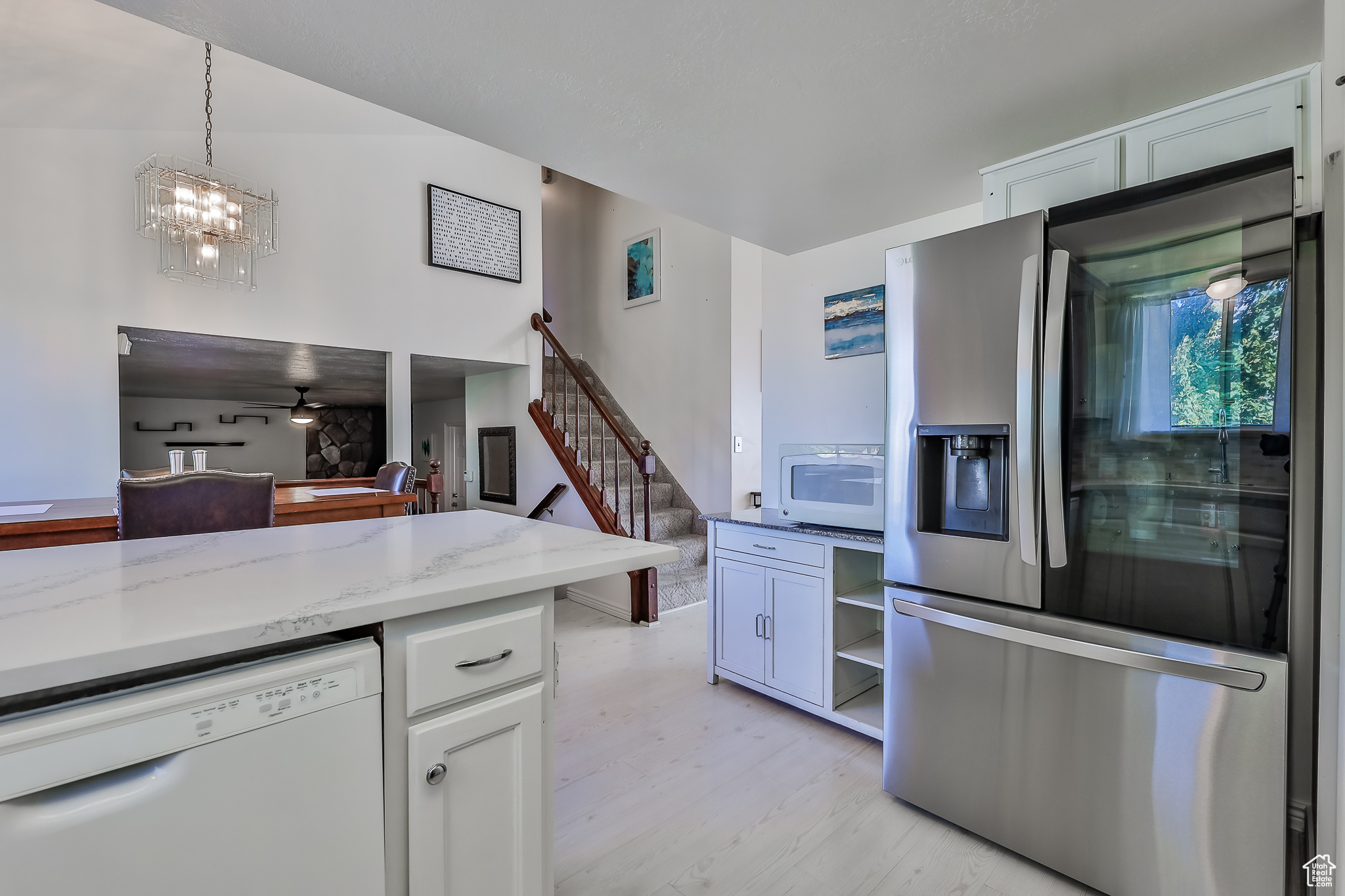 Kitchen with quartz counters, range hood, sink, white cabinets, and range with double oven oven