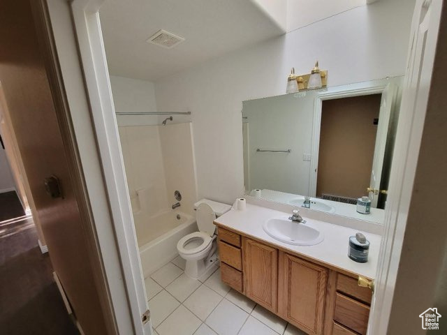 Full bathroom with toilet, tile flooring, vanity, and washtub / shower combination