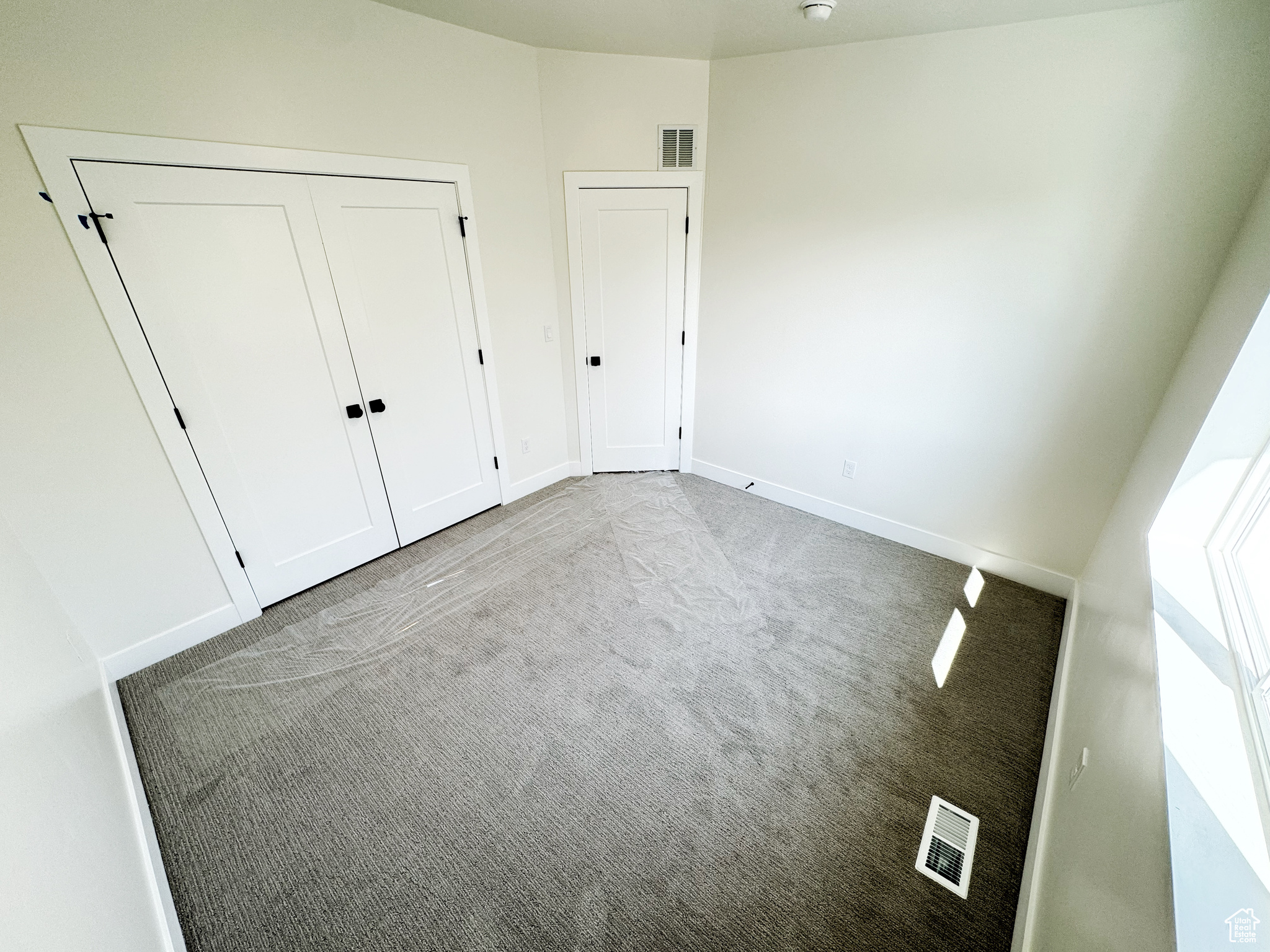 bedroom featuring light carpet and built in closet