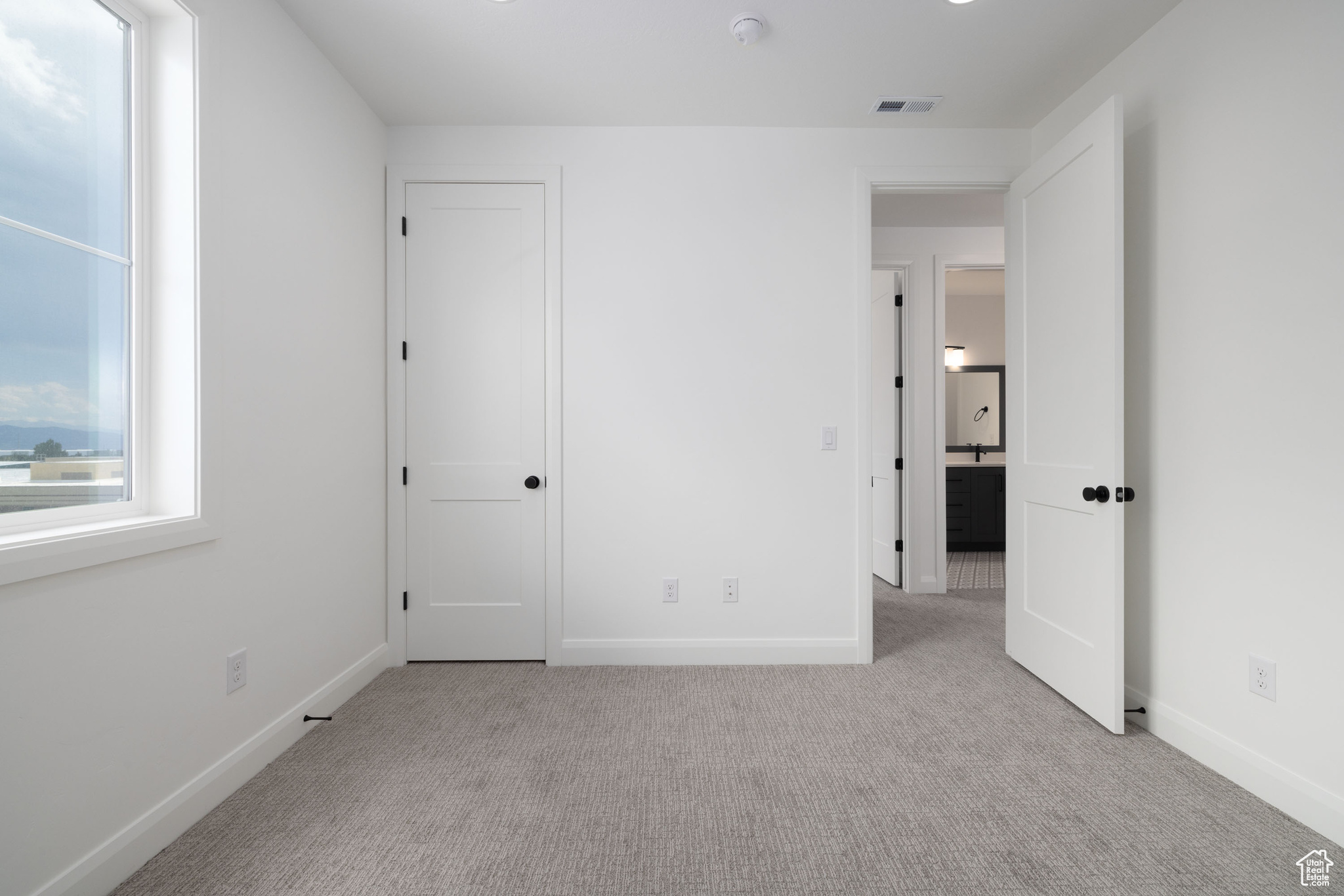 Unfurnished bedroom featuring light colored carpet