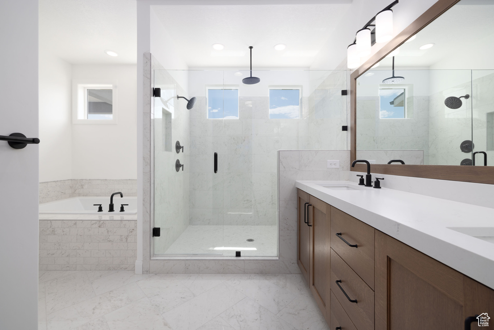 Bathroom with double vanity, plus walk in shower, and tile patterned flooring