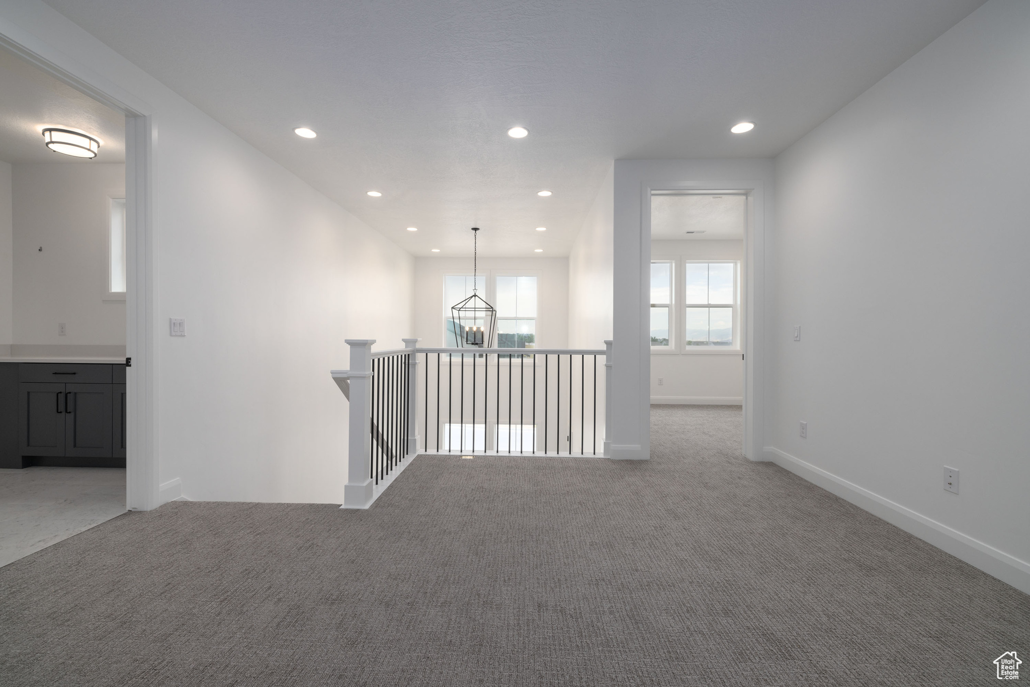 Empty room with a notable chandelier and light carpet