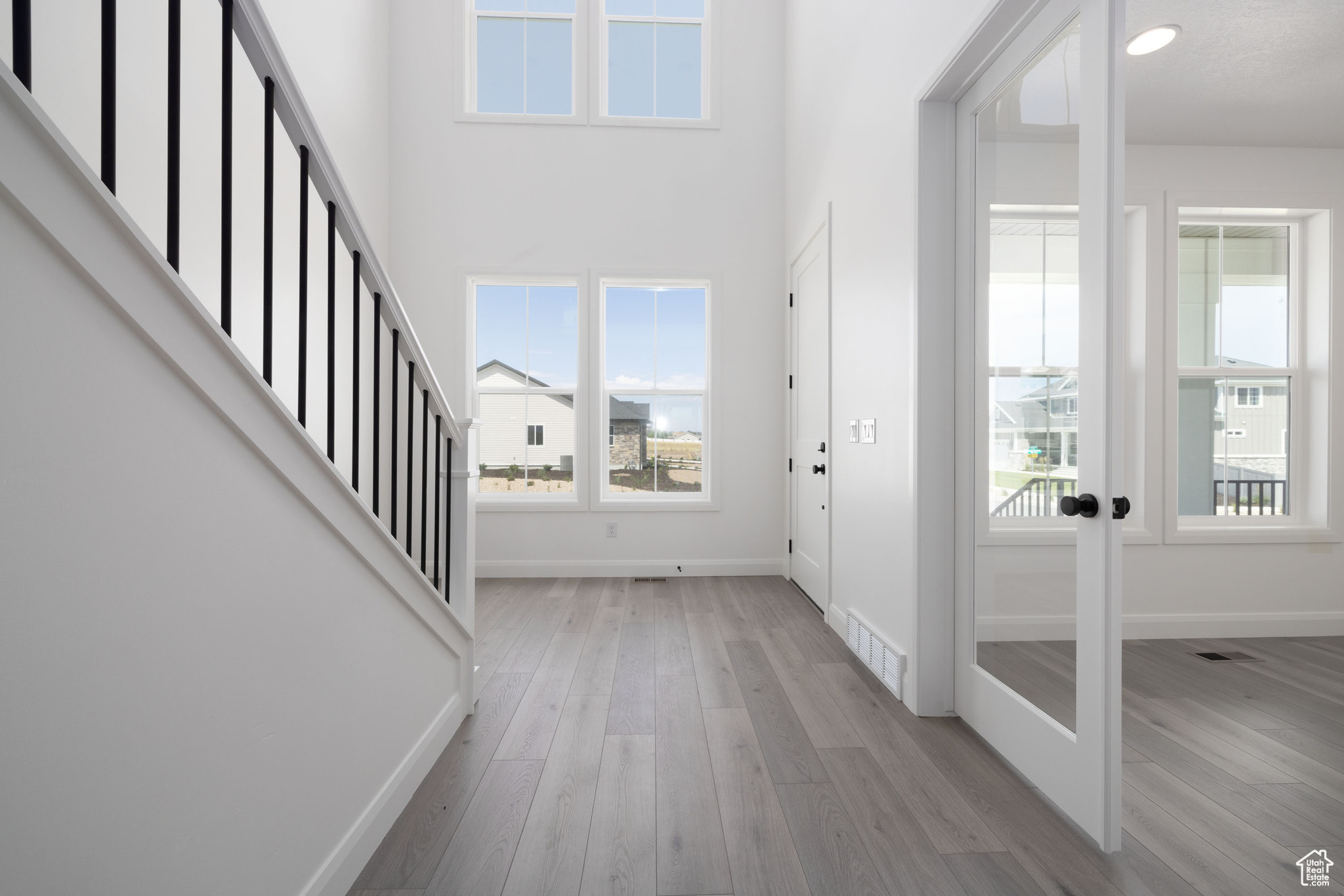 Entrance foyer with wood-type flooring, french doors, and a towering ceiling