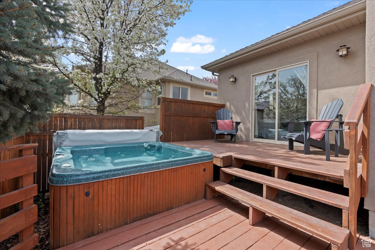 Wooden deck with a covered hot tub off primary suite