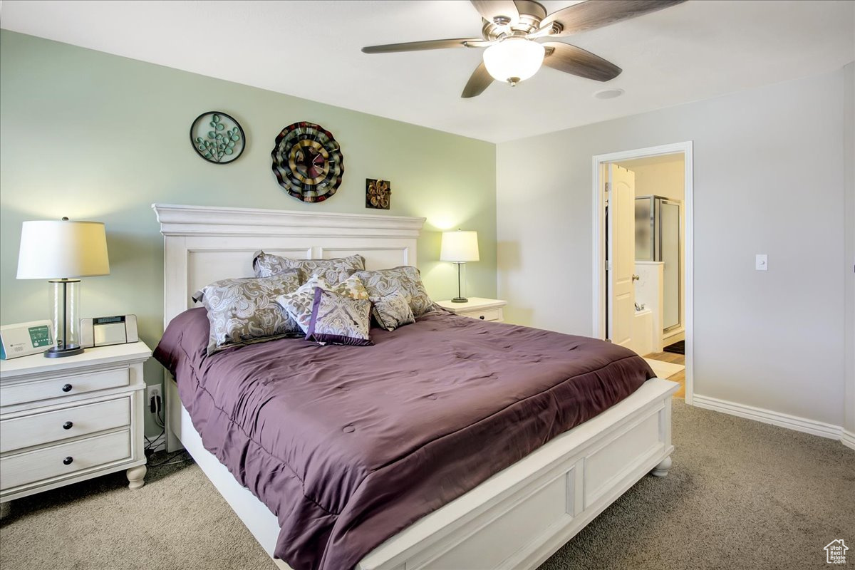 Master Bedroom with ensuite bath, ceiling fan, and dark carpet