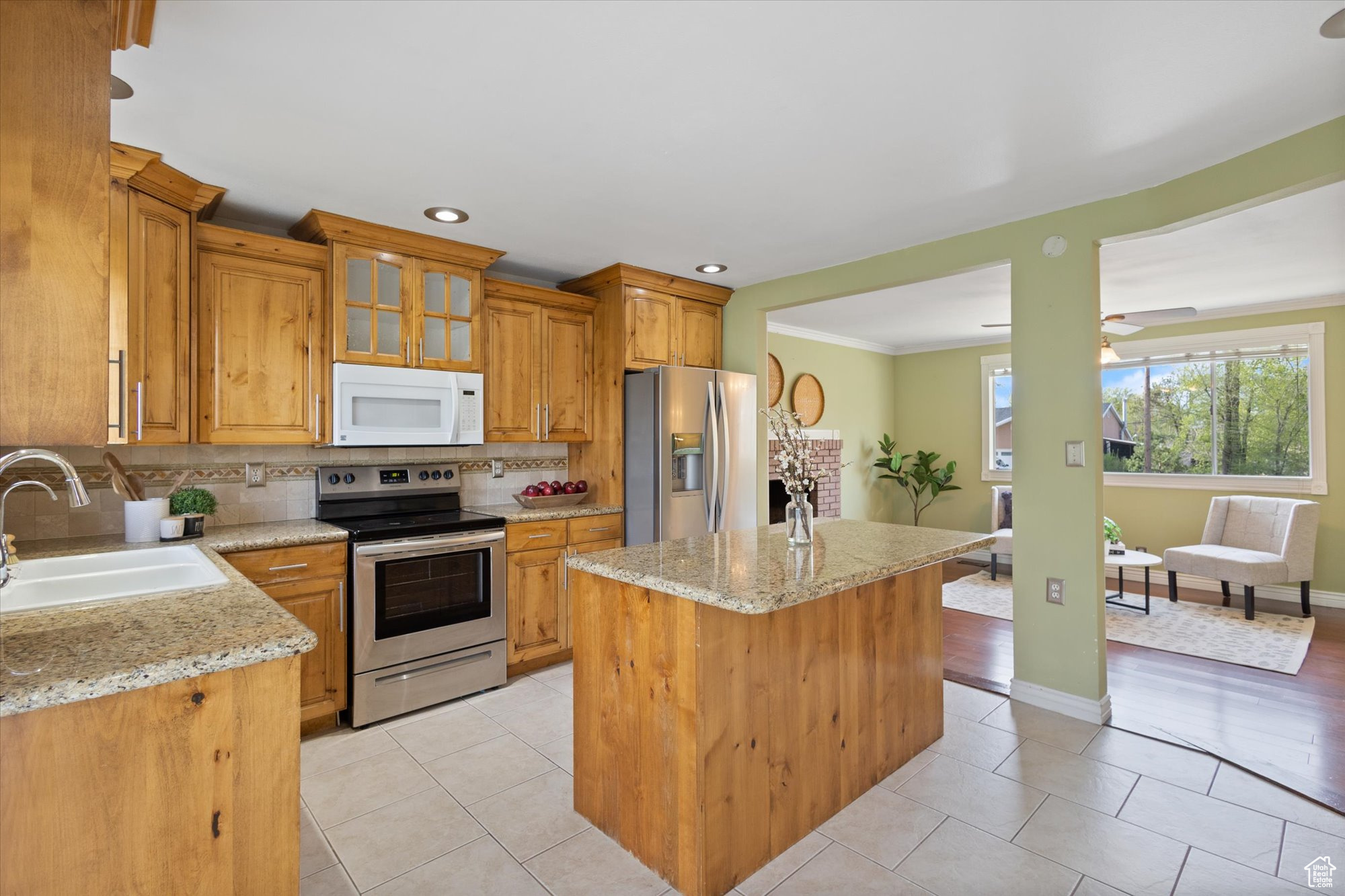 Kitchen with sink, appliances with stainless steel finishes, backsplash, and light tile floors
