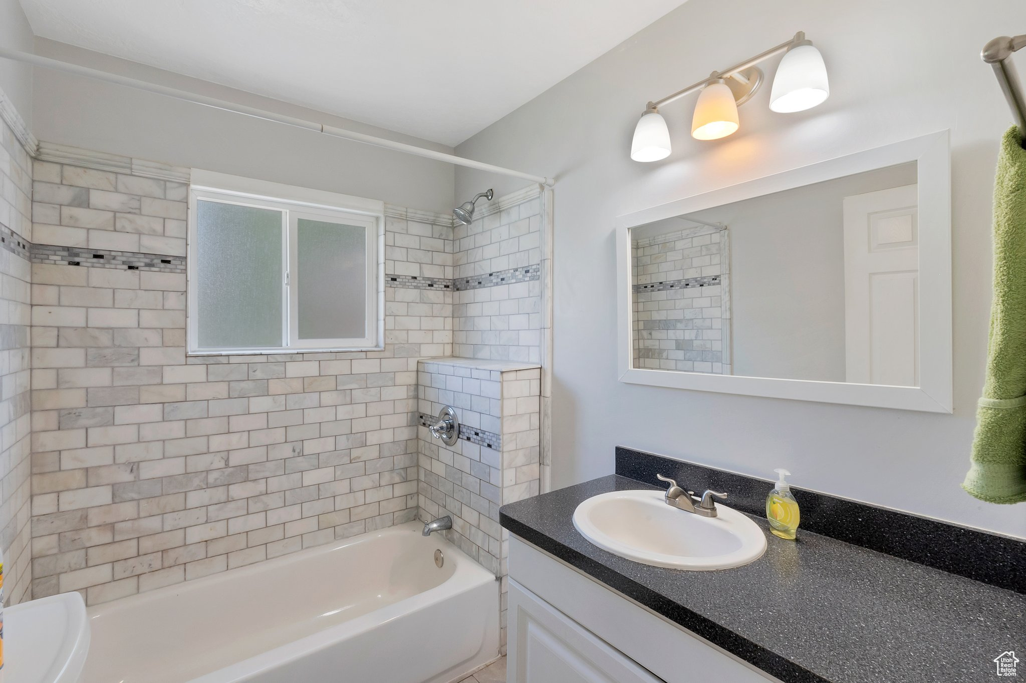 Full bathroom with vanity, toilet, and tiled shower / bath combo