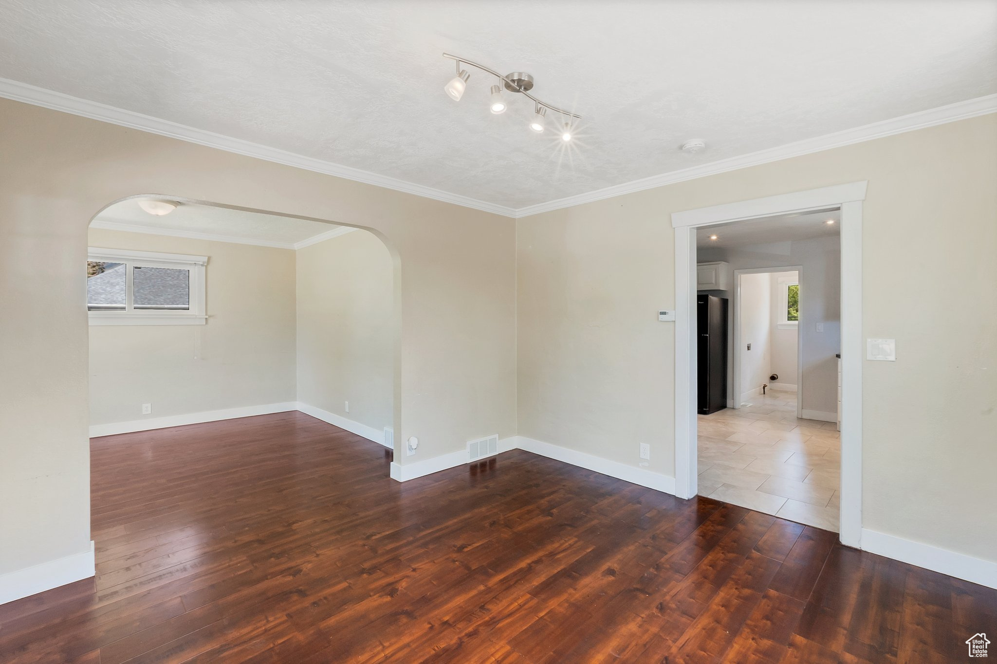 Unfurnished room with tile floors, crown molding, and rail lighting