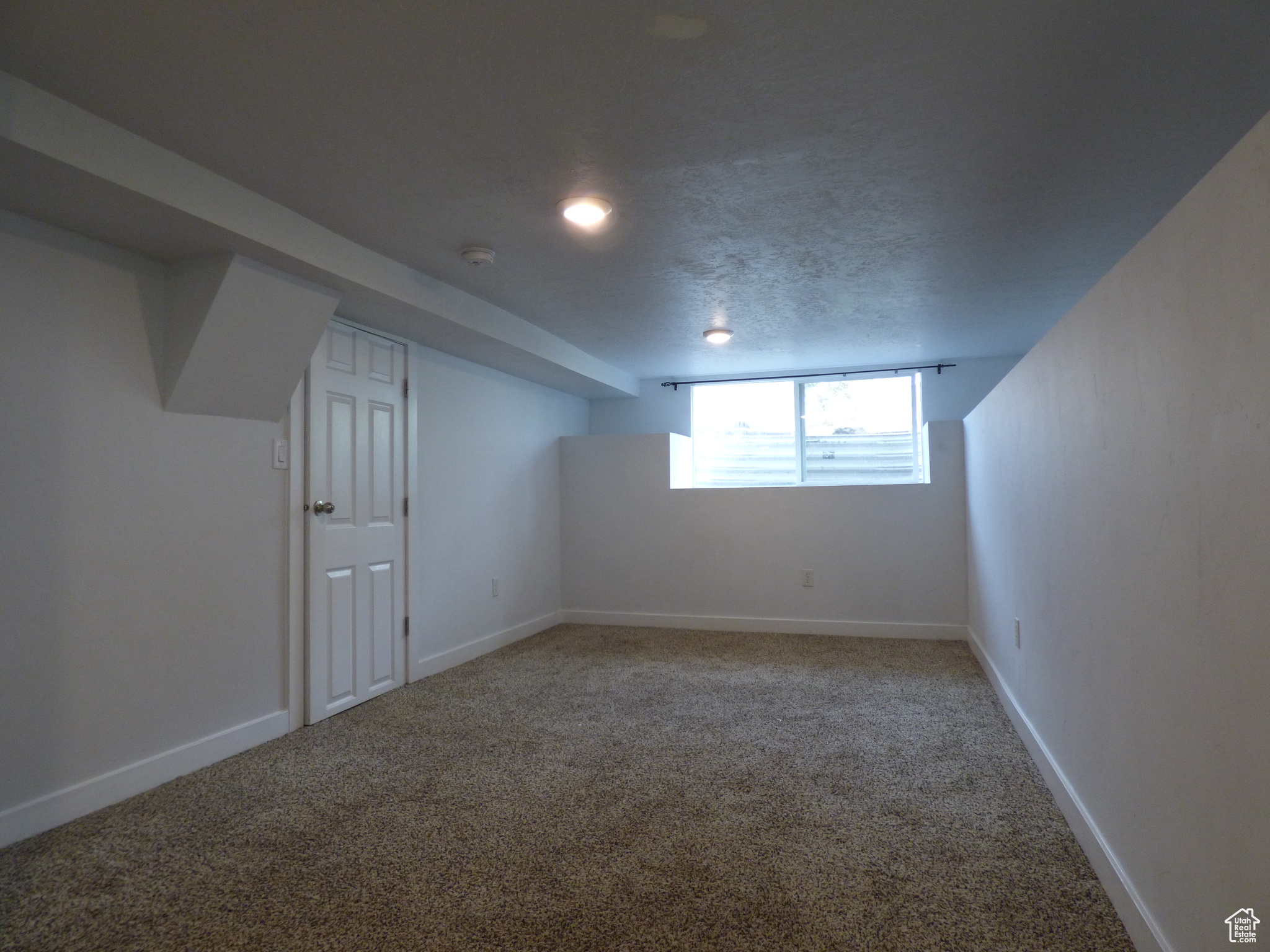 Bonus room with light carpet and a textured ceiling