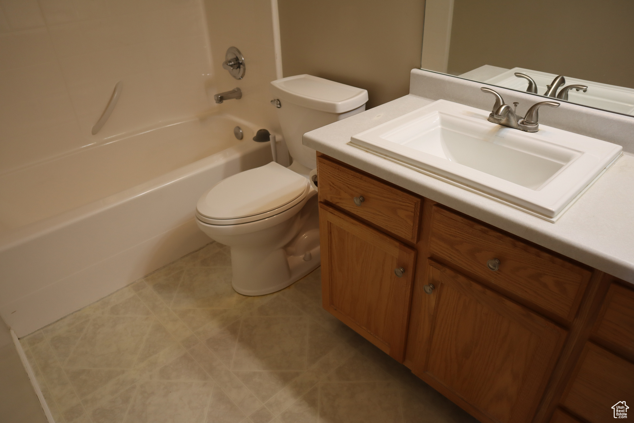 Full bathroom with shower / bathing tub combination, toilet, tile floors, and vanity