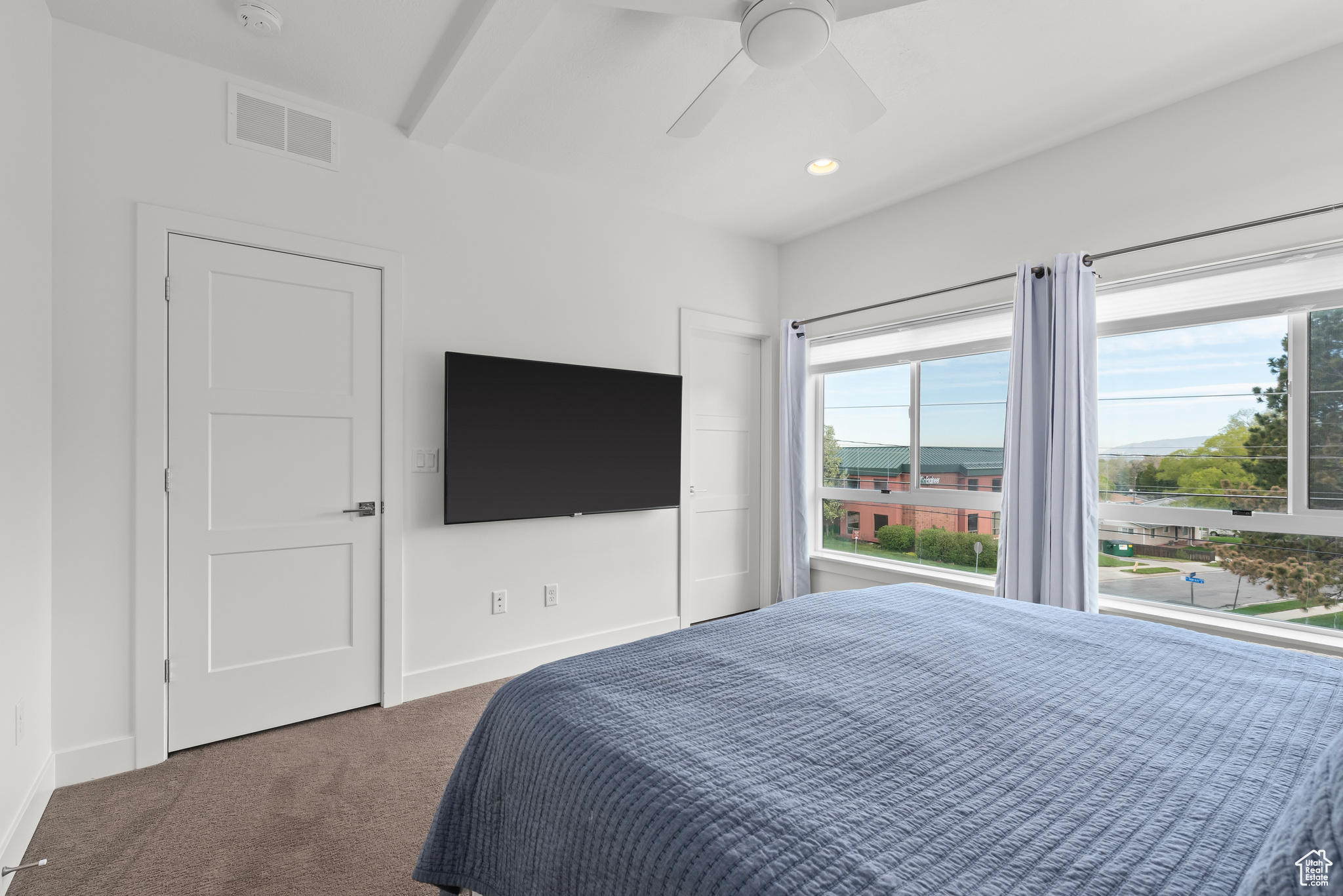 Owner bedroom featuring window view & ceiling fan