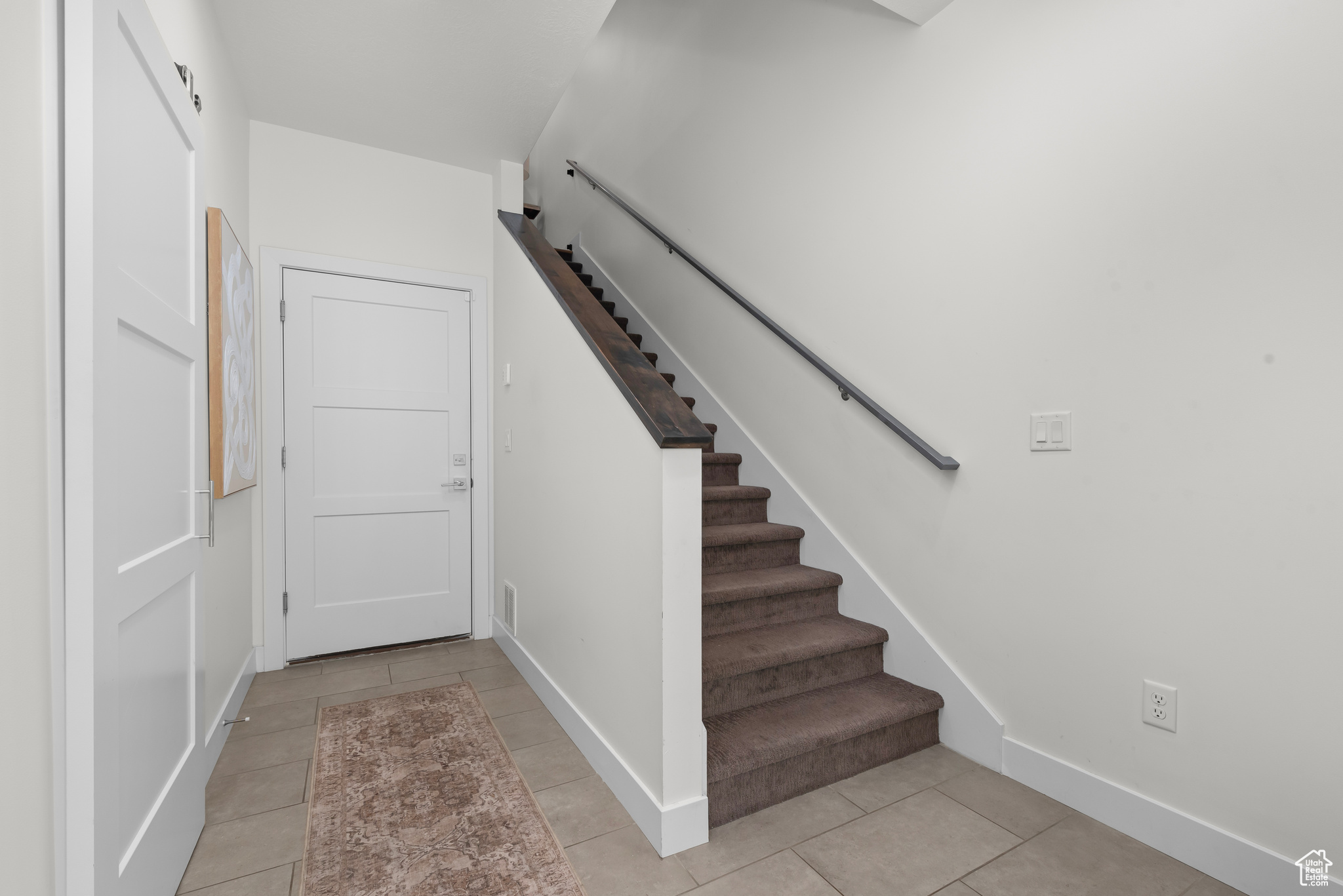 Maine level entry Stairs featuring light tile floors