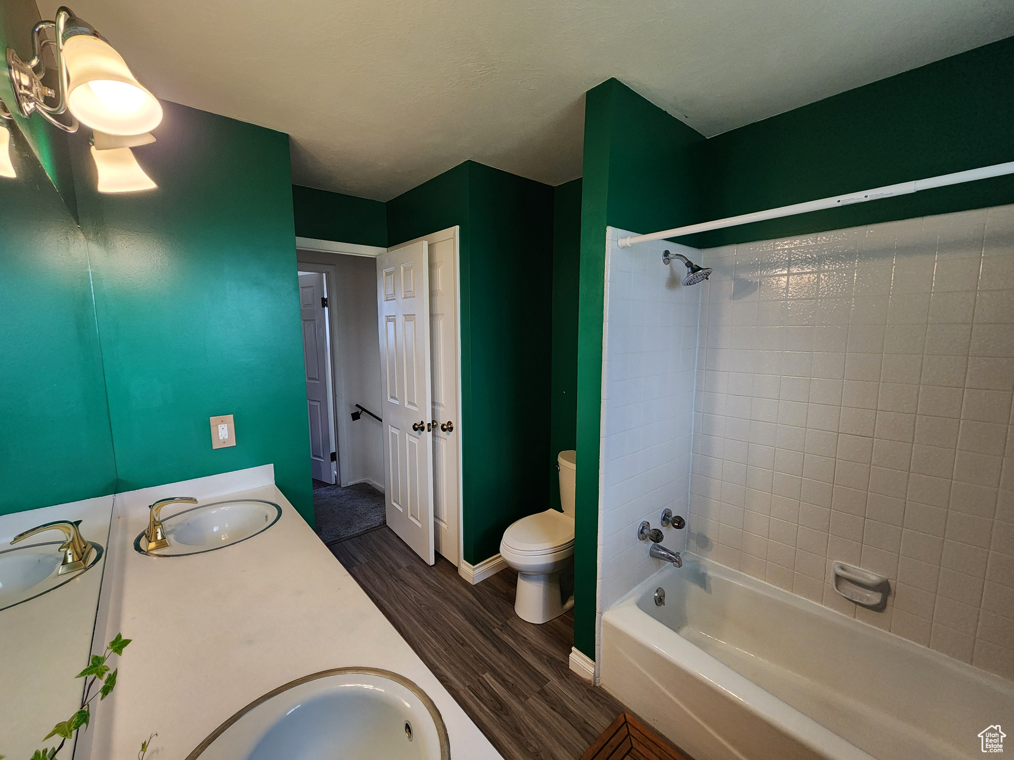 Full bathroom featuring wood-type flooring, vanity, toilet, and tiled shower / bath