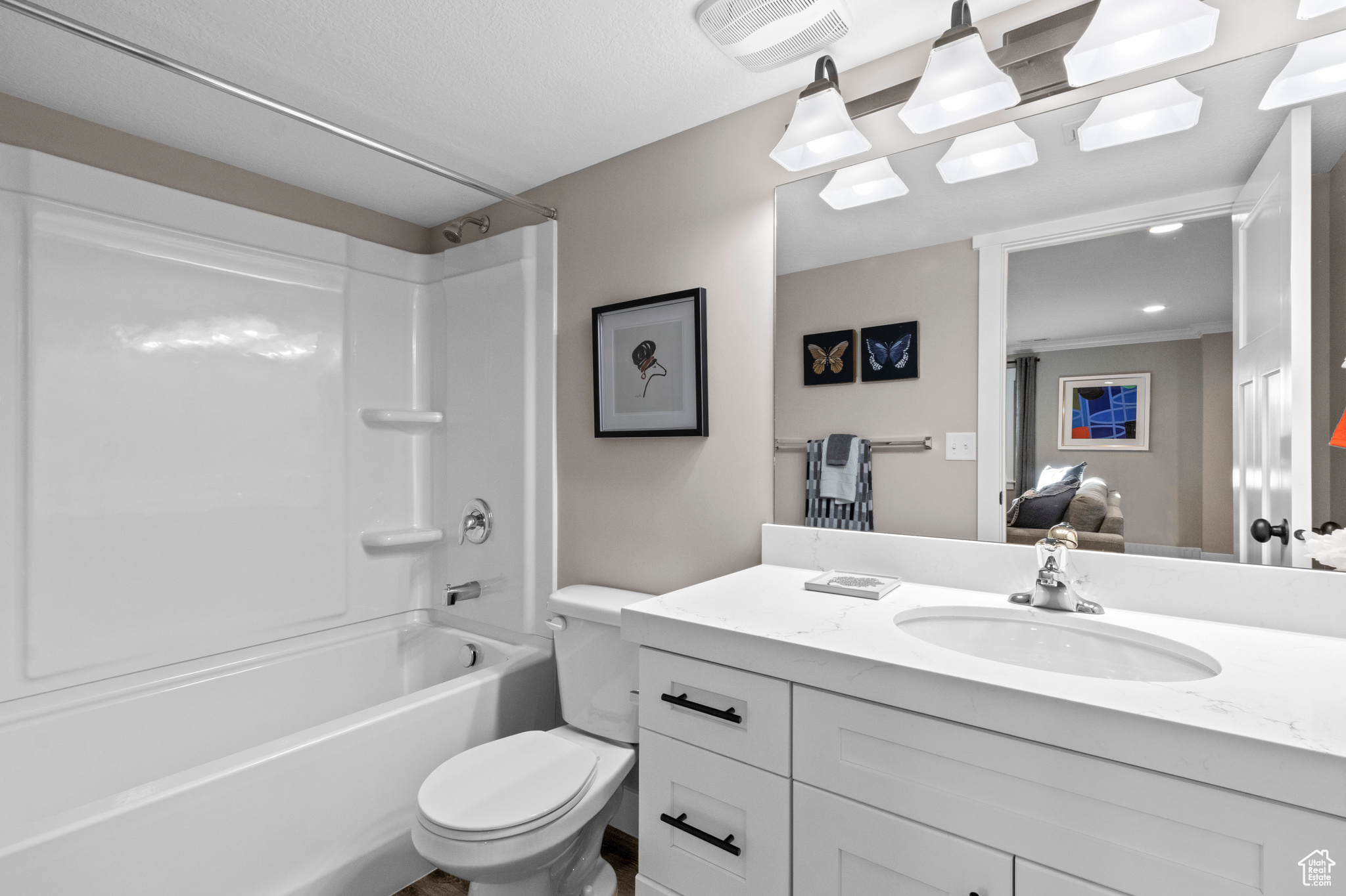 Full bathroom with washtub / shower combination, oversized vanity, crown molding, and toilet