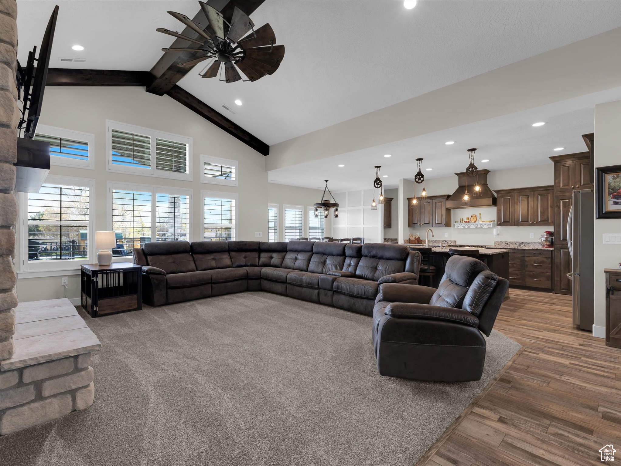 Living room with beamed ceiling, ceiling fan, high vaulted ceiling, and light wood-type flooring
