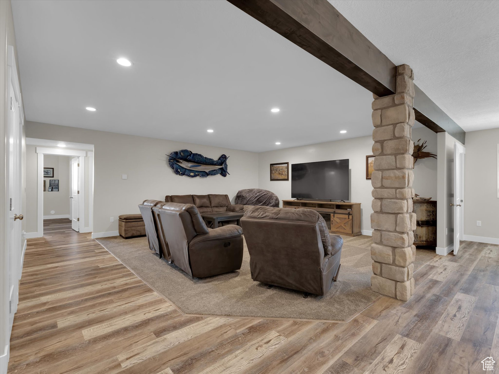 Living room featuring light hardwood / wood-style flooring, ornate columns, and beam ceiling