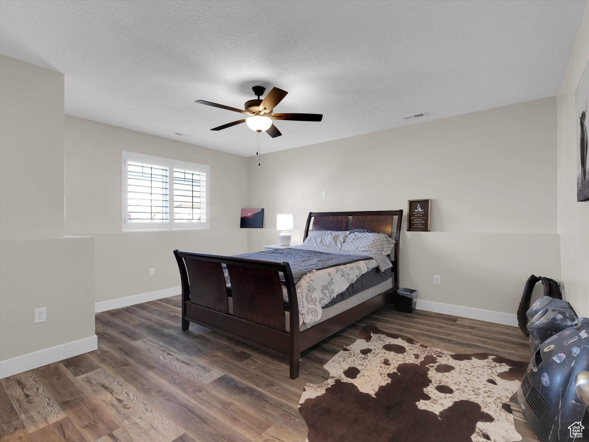 Bedroom #5 with dark hardwood / wood-style floors and ceiling fan