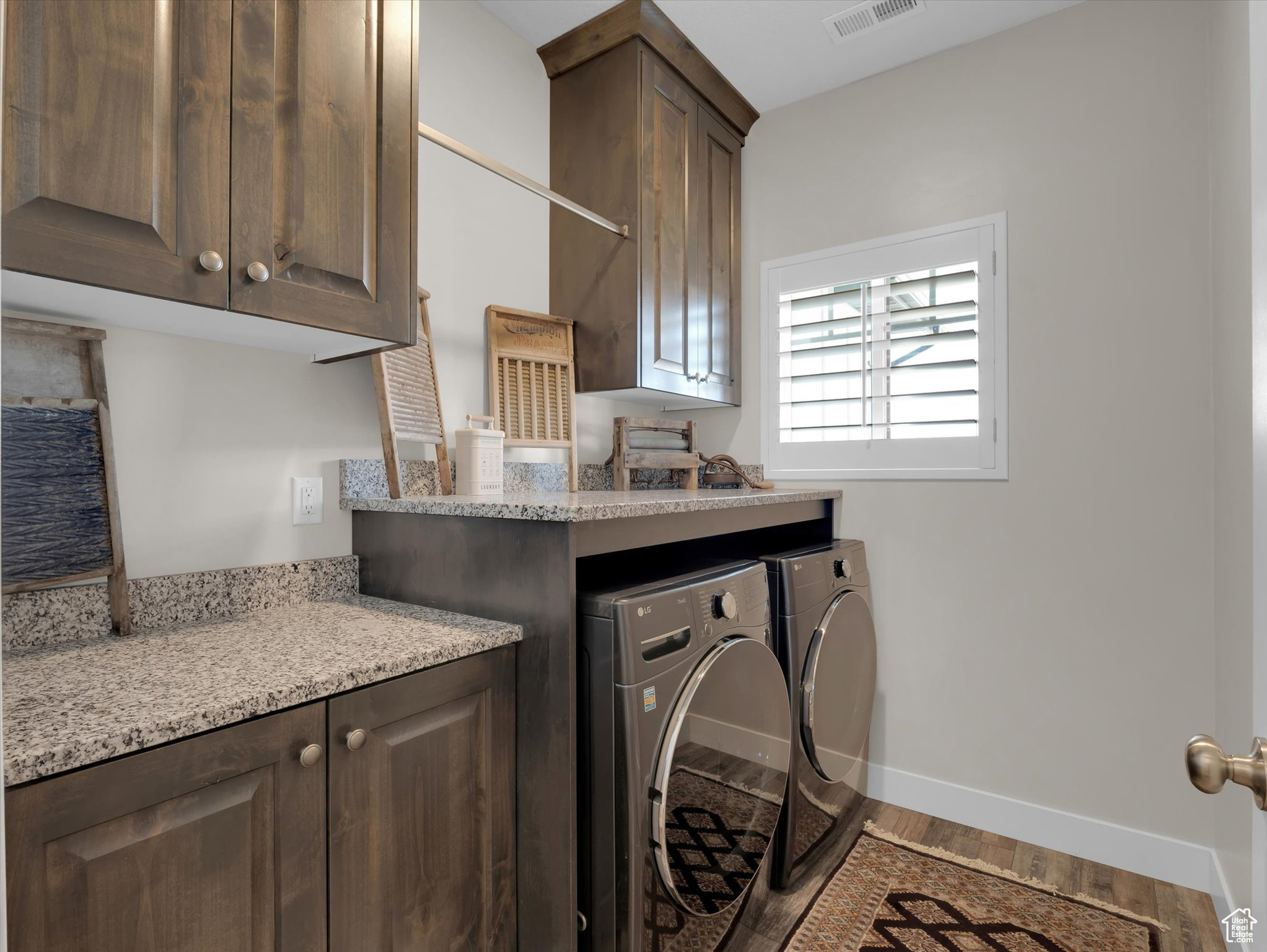 Laundry room featuring hardwood / wood-style floors, granite counter tops and cabinets
