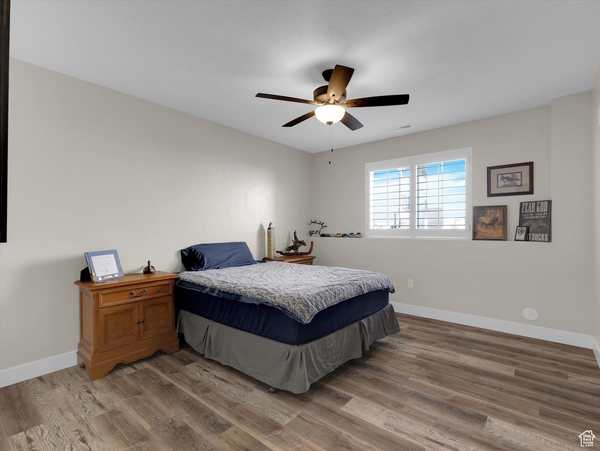 Bedroom #4 with ceiling fan and hardwood / wood-style flooring