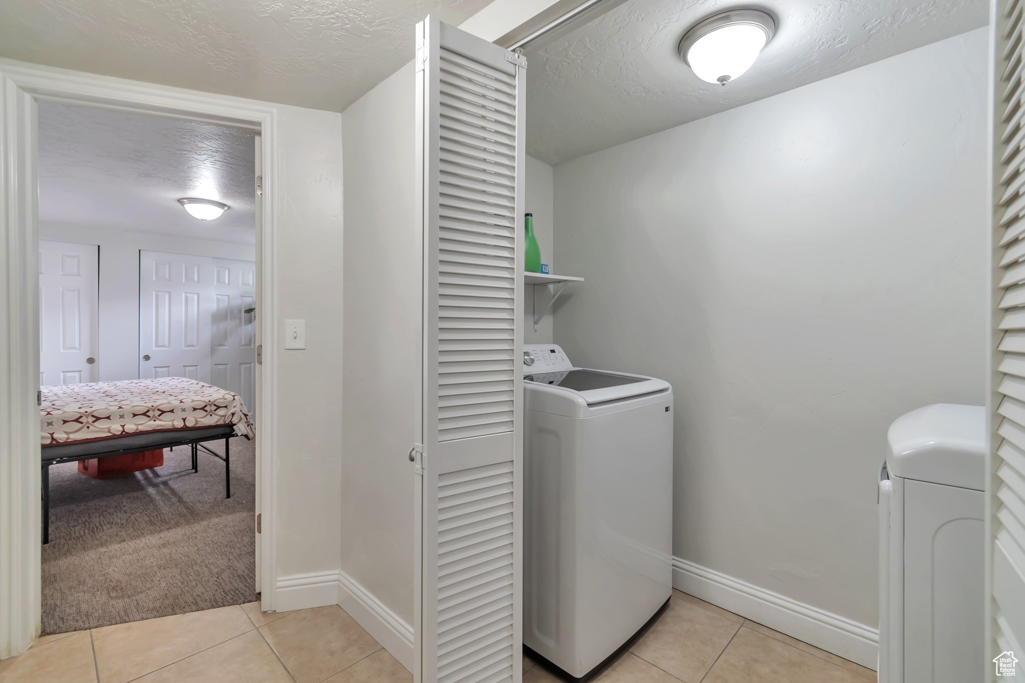 Laundry room featuring light carpet and washer and clothes dryer