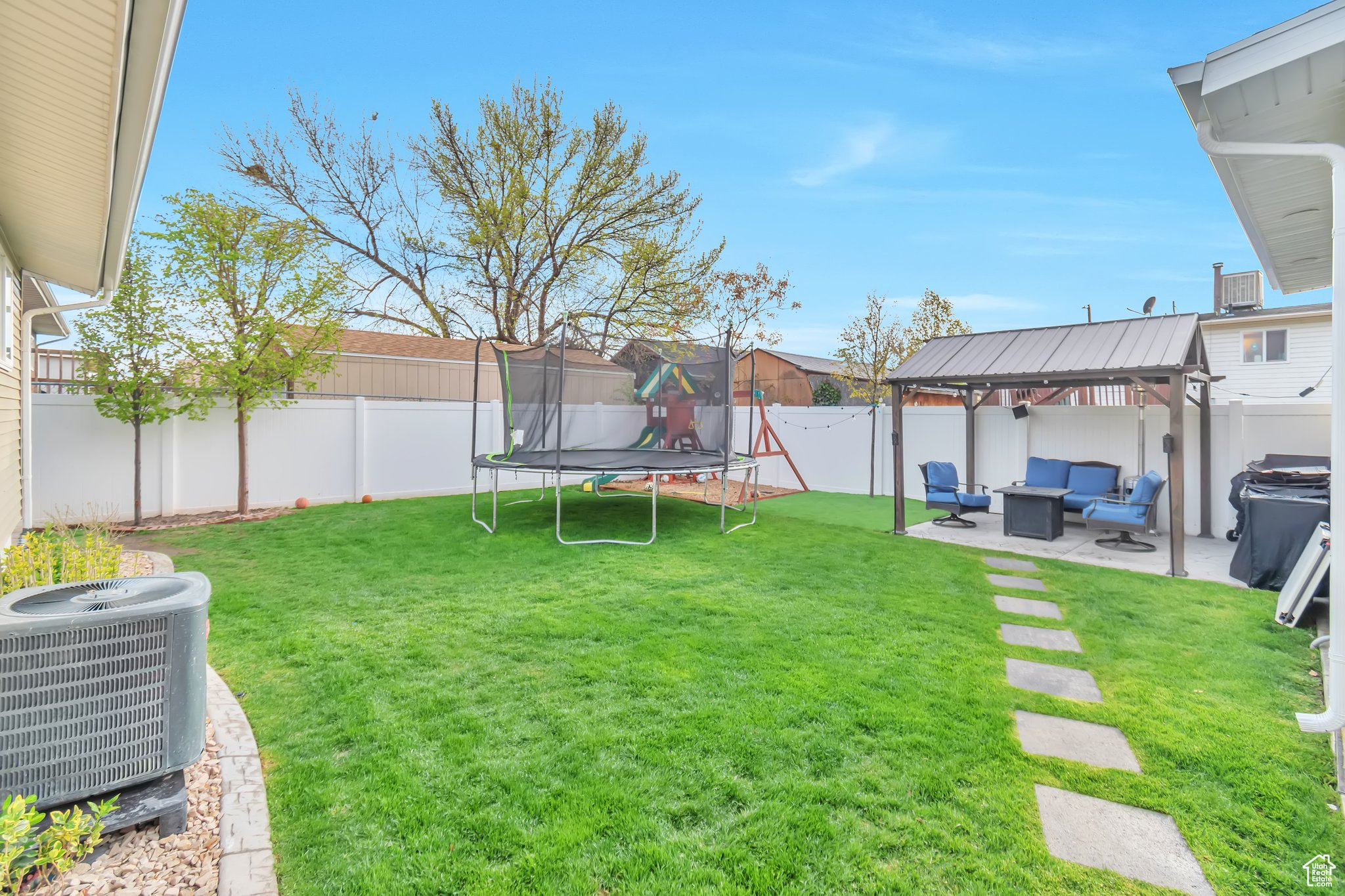 View of yard with a patio area, a trampoline, outdoor lounge area, central AC, and a gazebo