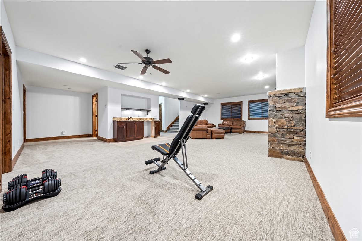 Workout area featuring light carpet and ceiling fan