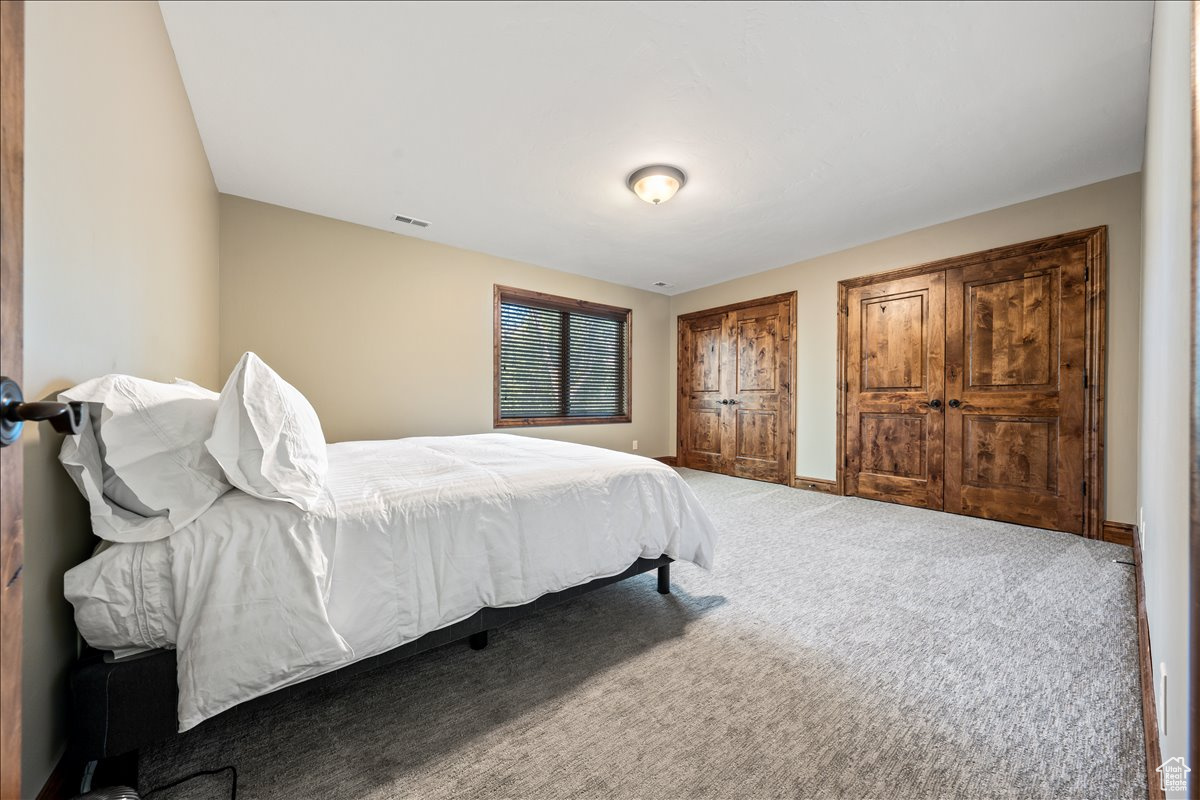 Carpeted bedroom with multiple closets