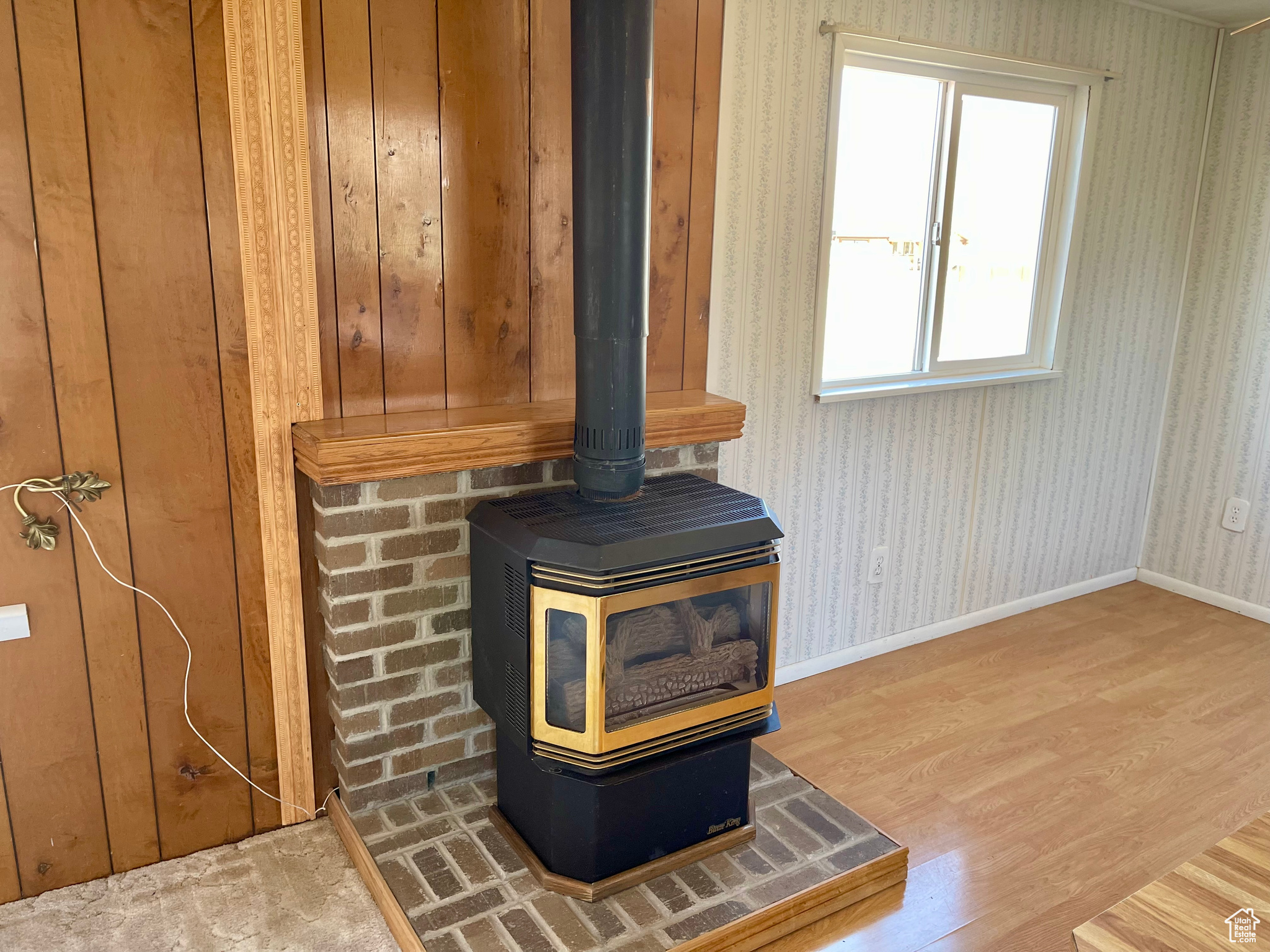 Details featuring a wood stove, wood walls, and wood-type flooring