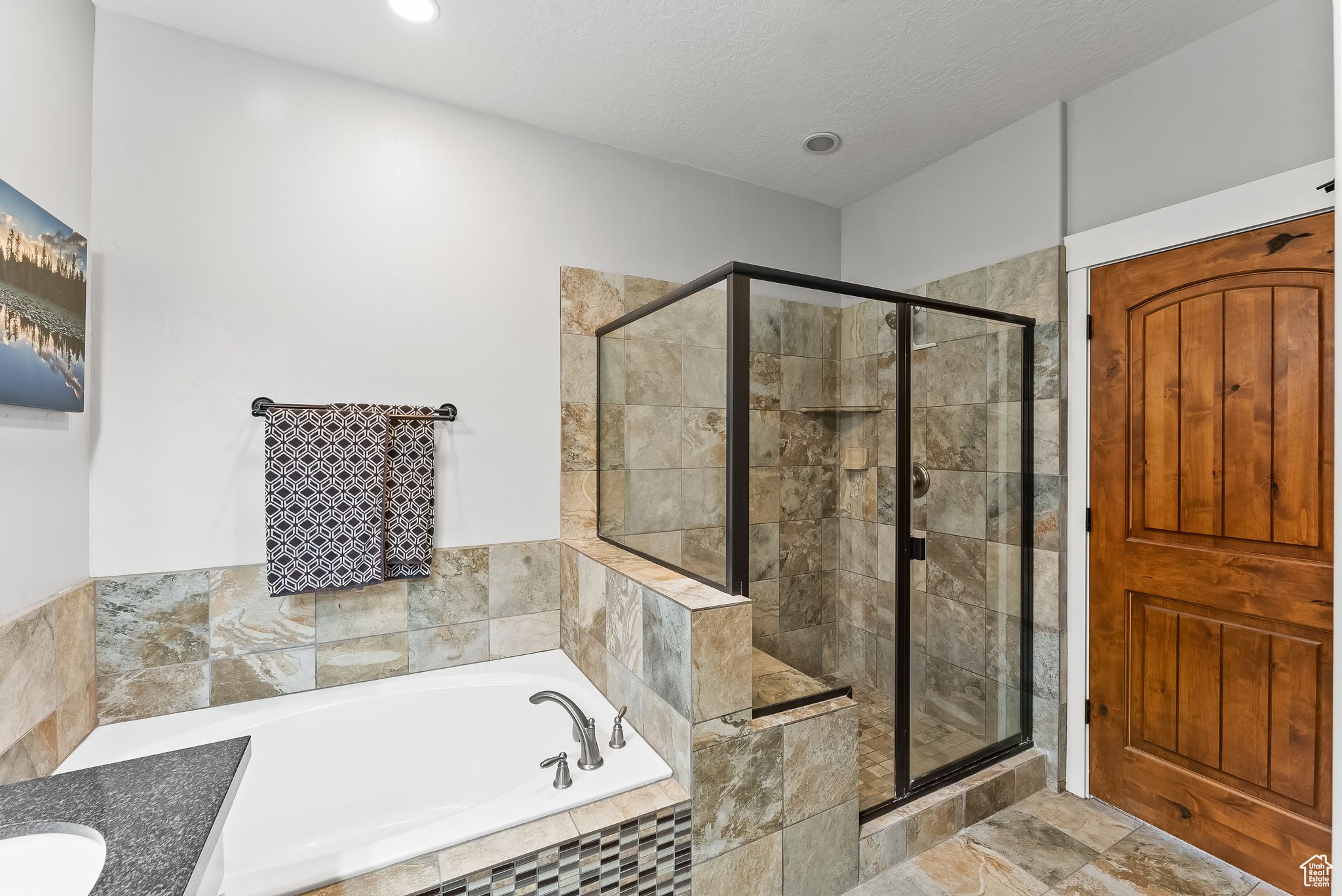 Bathroom with tile flooring, vanity, a textured ceiling, and separate shower and tub