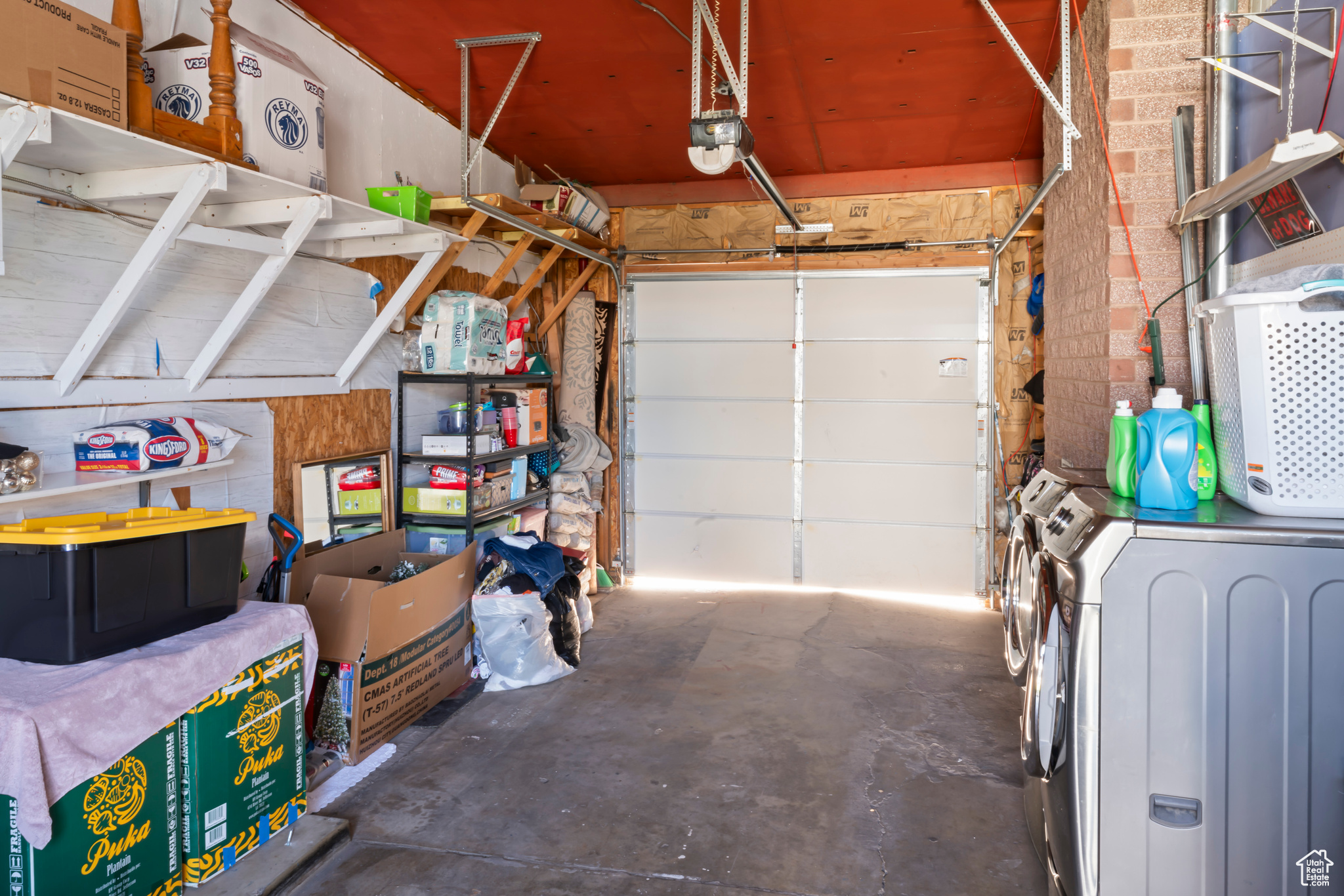 Garage featuring washer and dryer and a garage door opener