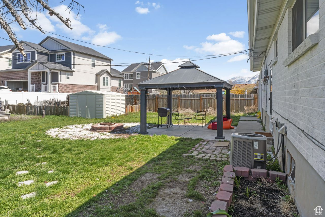 View of yard with a patio area, a gazebo, central AC, and a storage shed