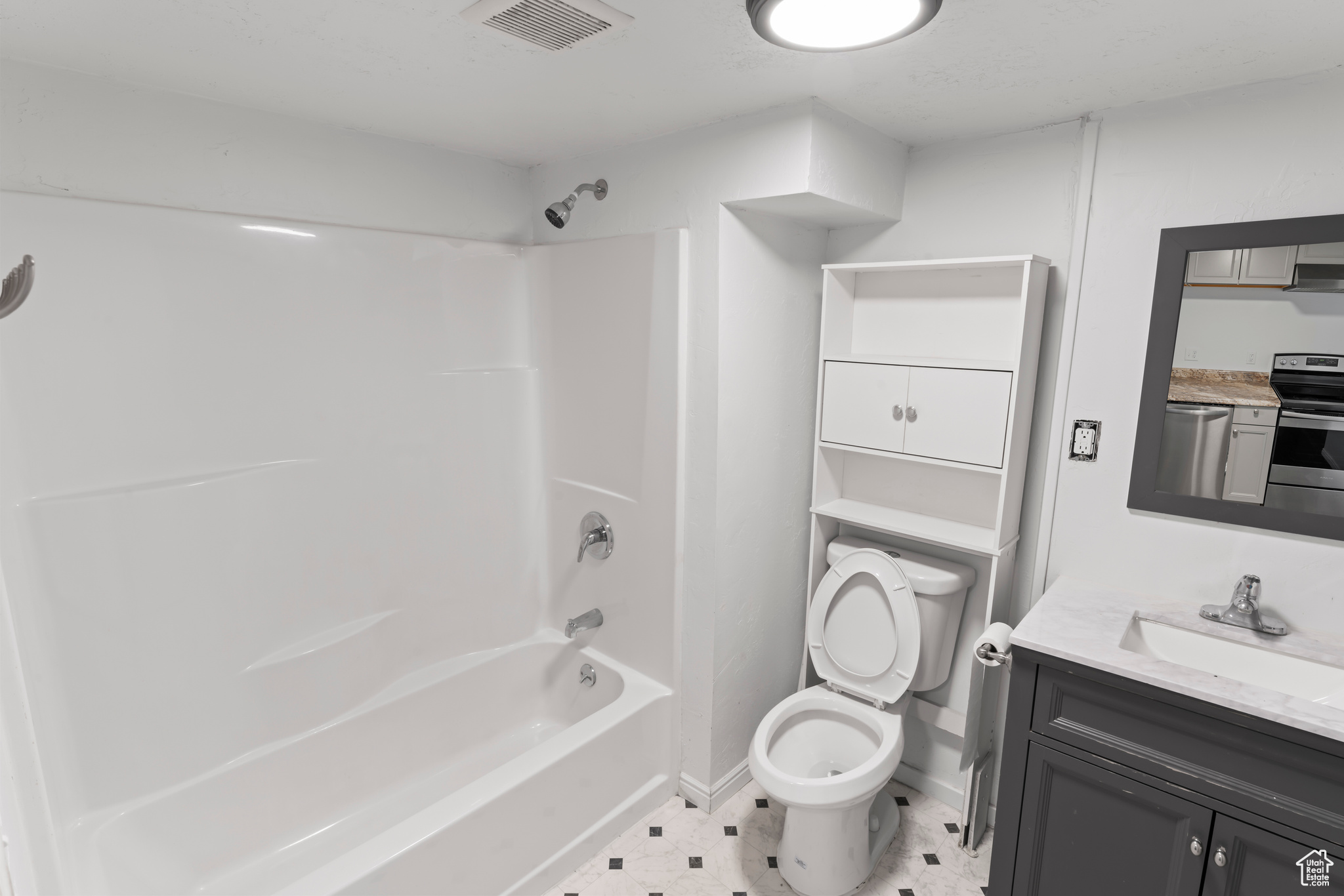Full bathroom featuring vanity, shower / tub combination, tile floors, and toilet