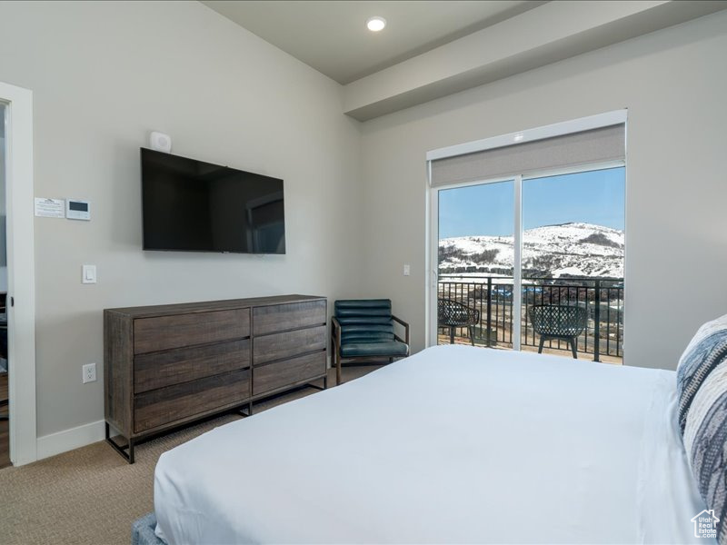 Carpeted bedroom featuring a mountain view and access to exterior