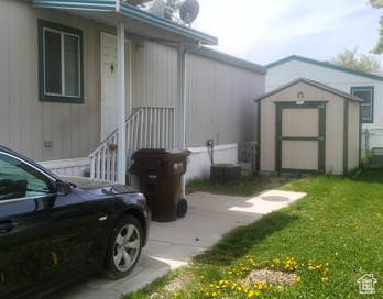 View of side of property with a storage shed