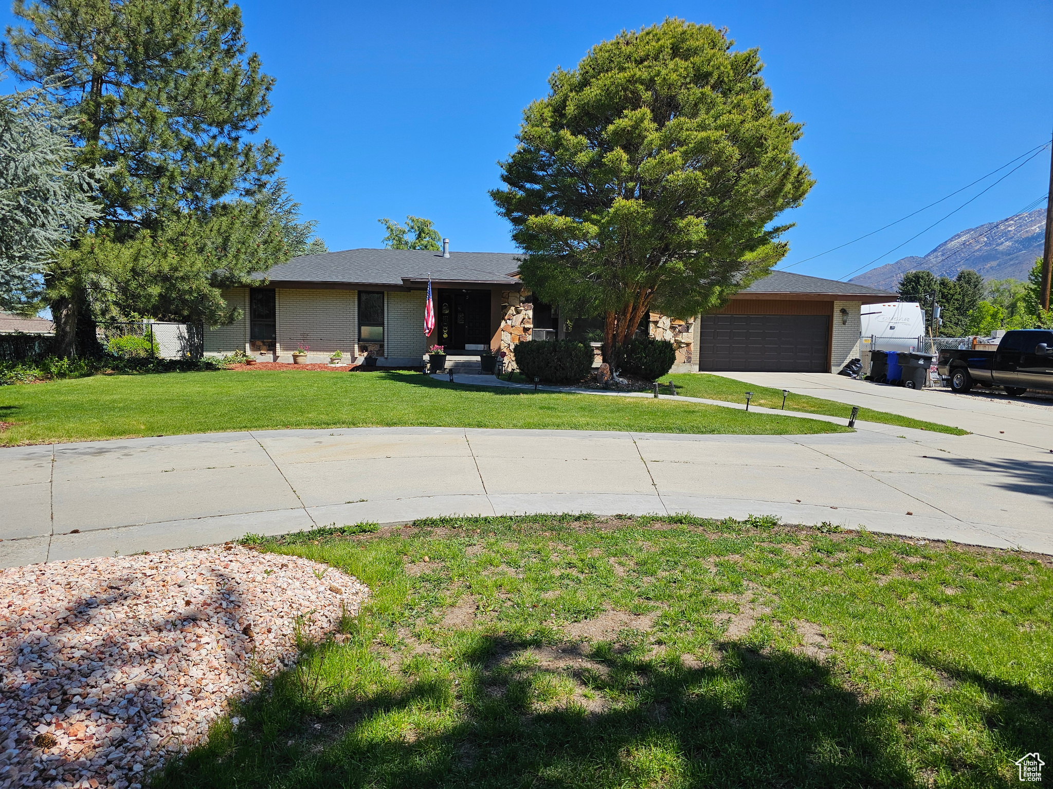 Ranch-style house with a garage, a mountain view, and a front yard