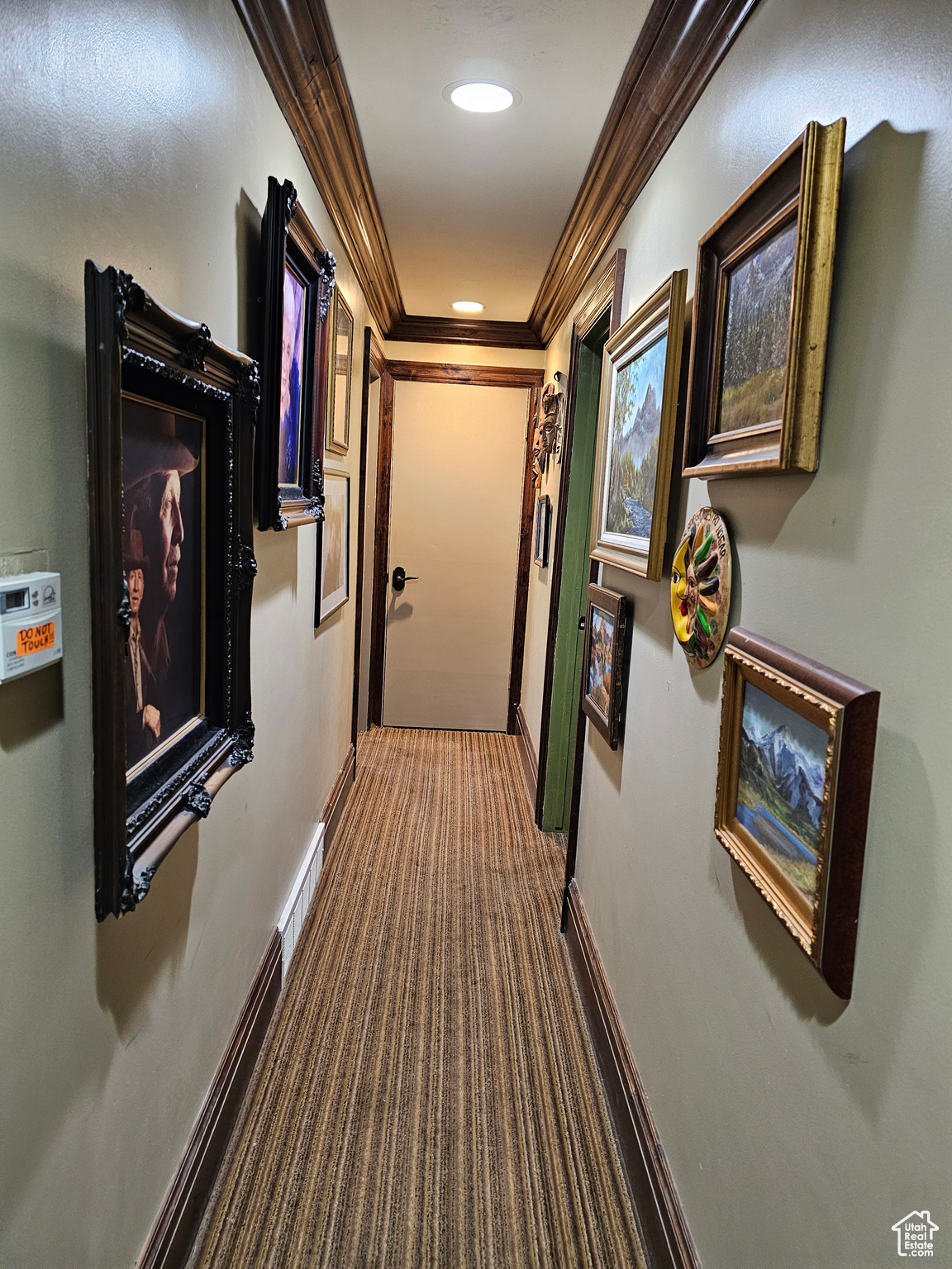 Hall with dark colored carpet and ornamental molding